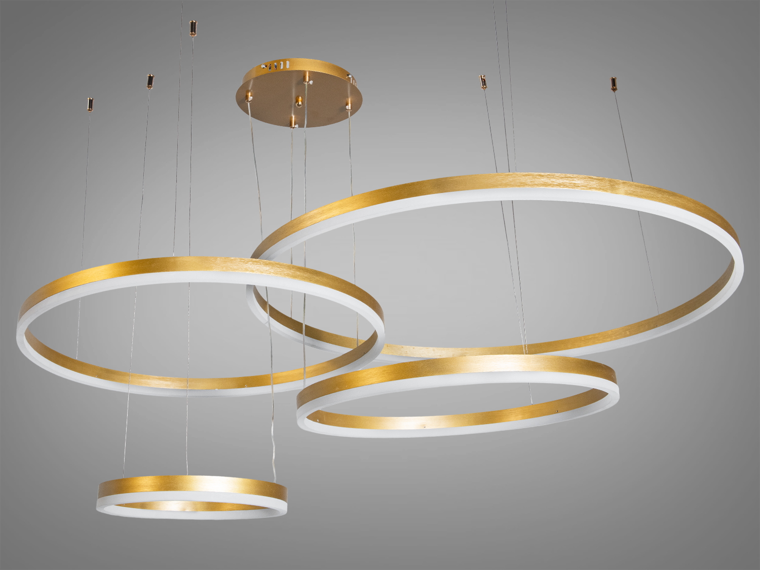 Підвісний світильник з трьома золотими кільцями, що підходить для монтажу на стелі, створює елегантний акцент в інтер′єрі.