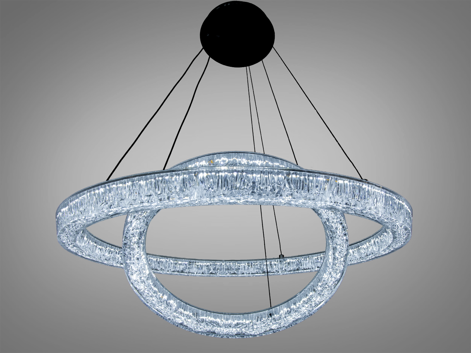 Сучасний світильник з акриловими кільцями, підвішений на чорних тросах, ідеальний для високих стель.