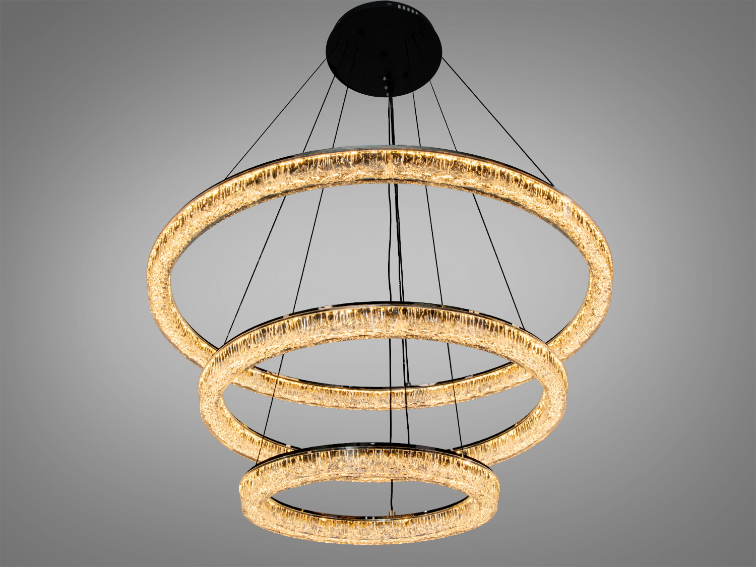 Підвісна люстра з трьома акриловими кільцями, тепле освітлення. Кільця різного діаметра, підходить для вітальні або їдальні.