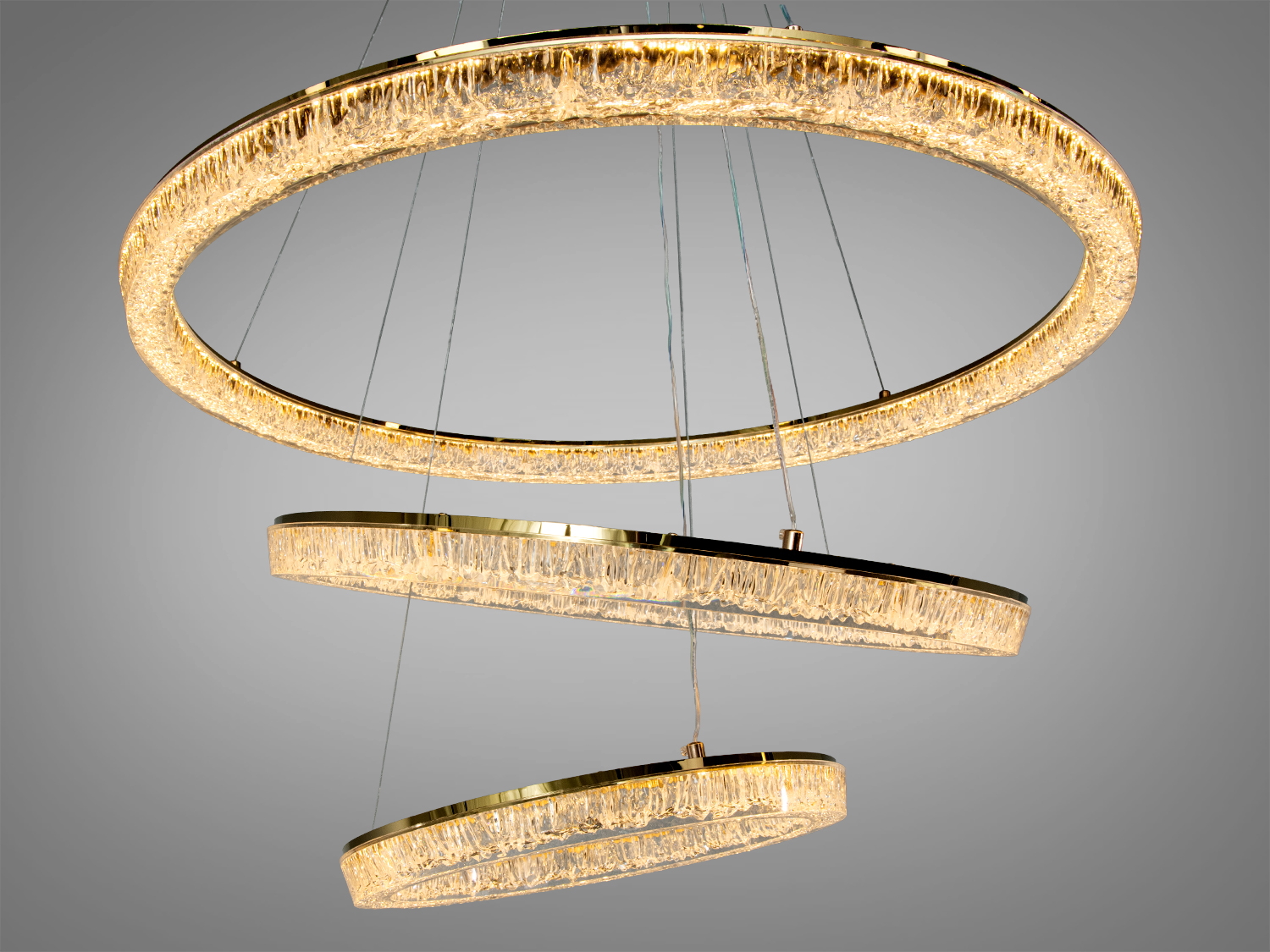 Люстра з трьома підвісними кільцями, що створюють тепле світло, ідеально підходить для вітальні або їдальні.