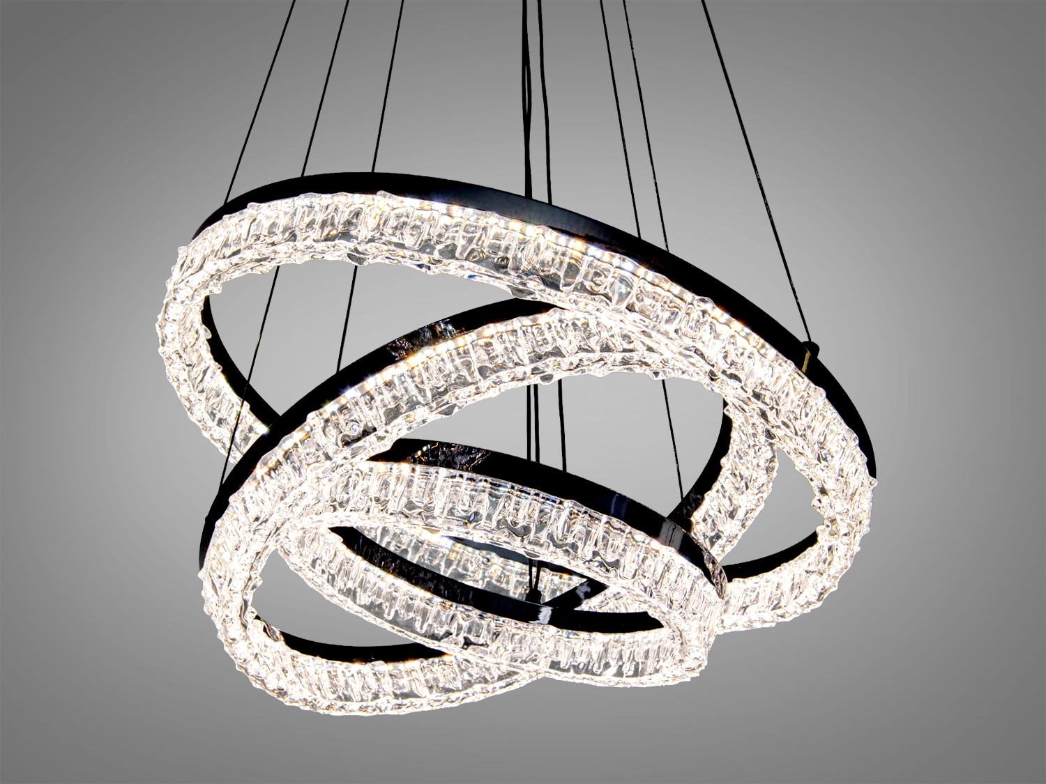 Люстра з трьома акриловими кільцями, підвішена на тонких дротах, забезпечує рівномірне освітлення. Підходить для просторих кімнат.