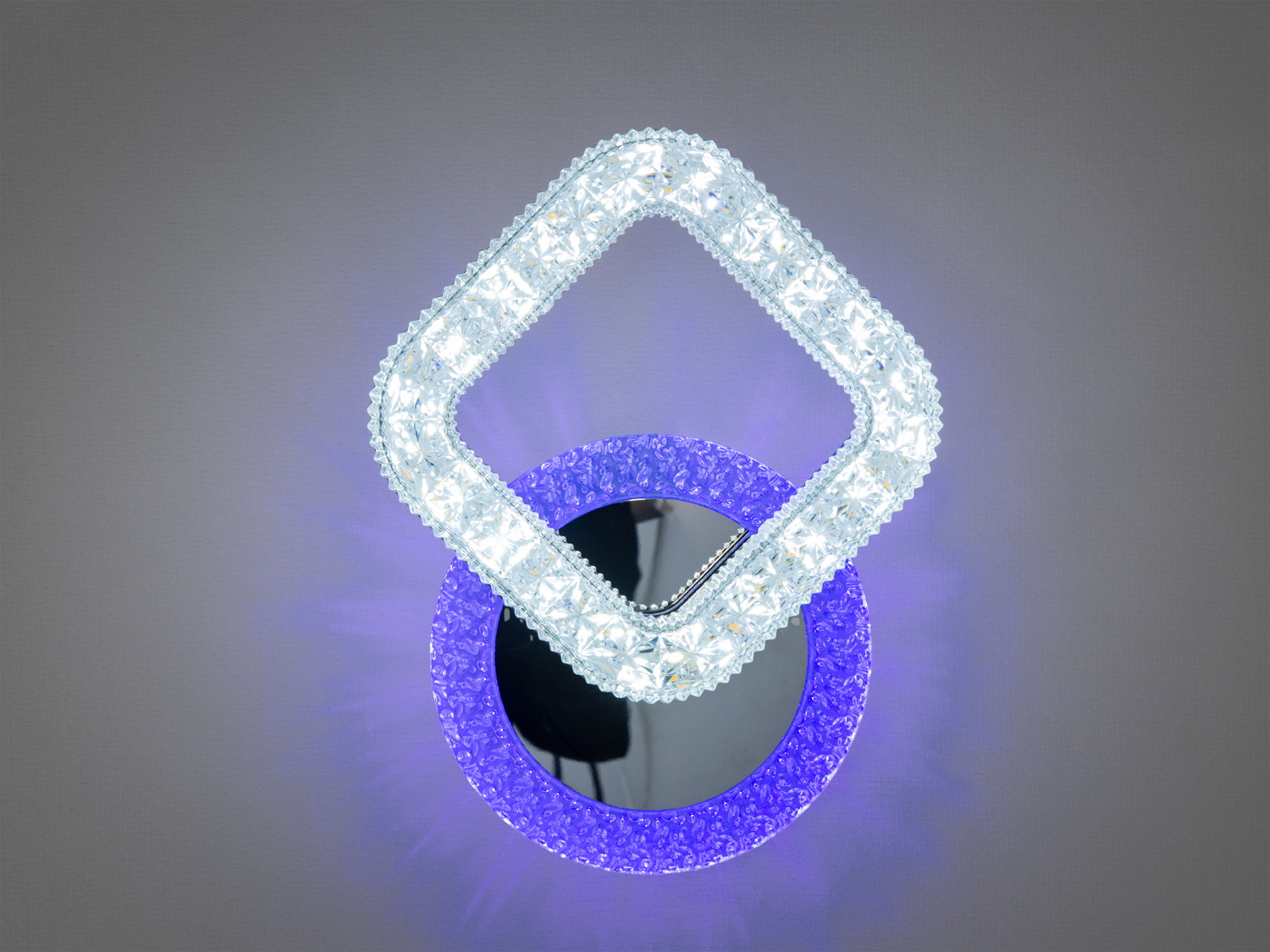 Настінний світильник з LED-каркасом у формі ромба, що випромінює біле світло. Кругла основа з декоративним фіолетовим світлом.