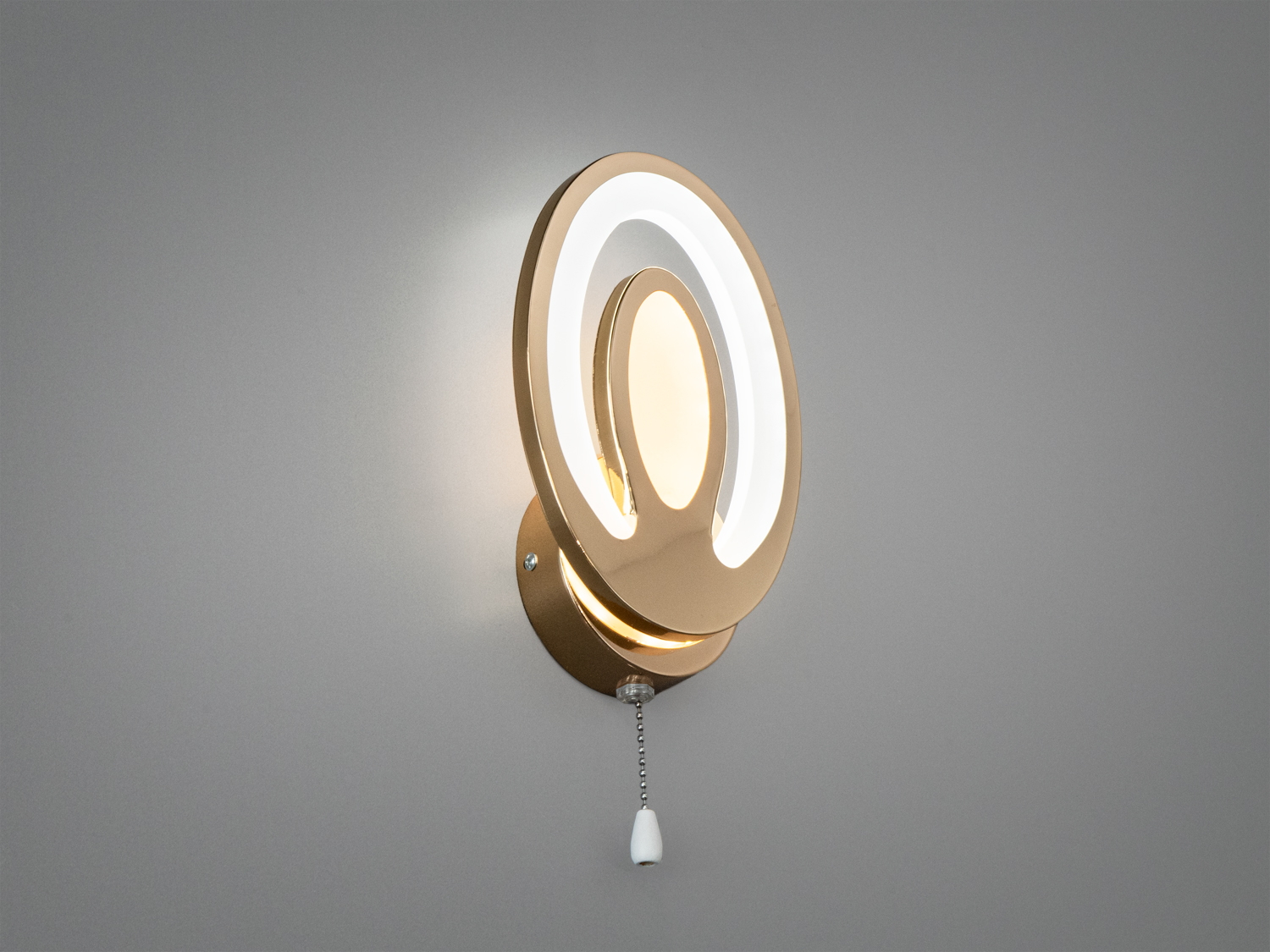 Настінний світильник з овальною формою, золотистим покриттям та світлодіодним підсвічуванням. Має підвісний вимикач для зручного використання.
