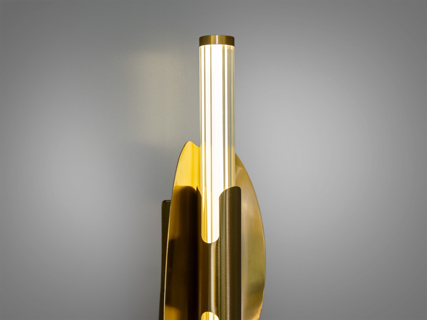 Деталь настінного світильника з металу в кольоры золота, акцент на прозорих акрилових циліндричних розсыювачах, підходить для акцентного освітлення.