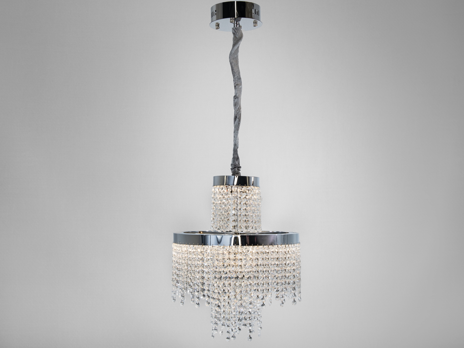 Люстра з каскадними кришталевими підвісками, що створюють ефект водоспаду. Хромована основа підкреслює сучасний стиль.