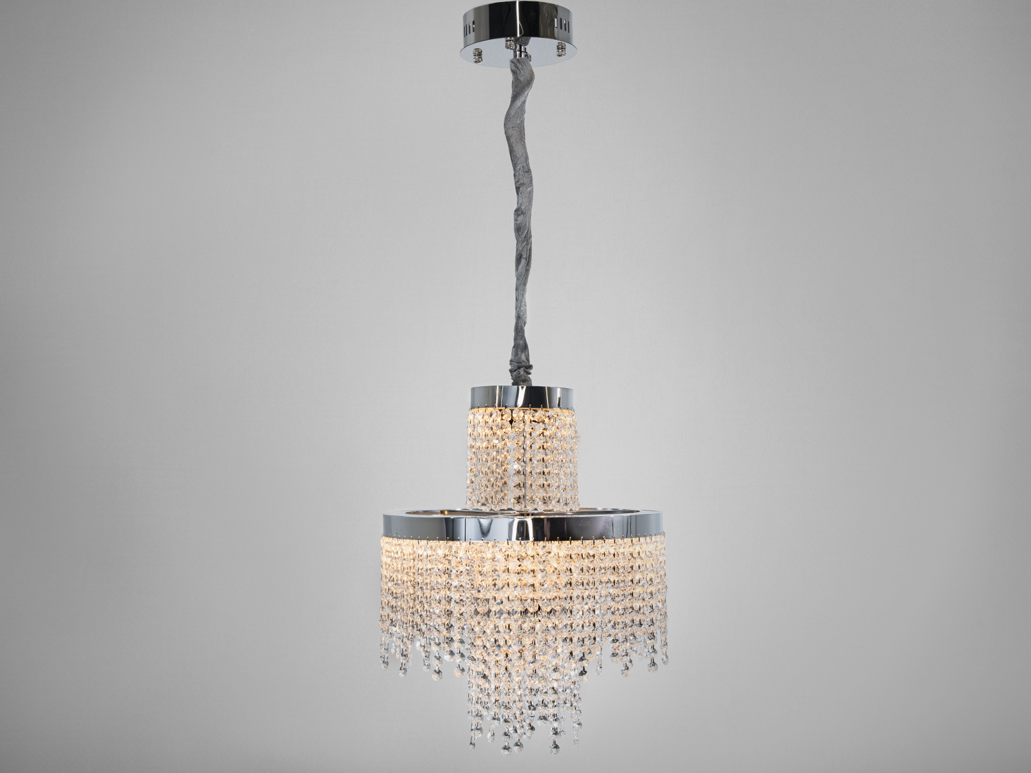 Елегантна люстра з кришталевими підвісками, підвішена на витонченому тросі. Підходить для класичних інтер′єрів.