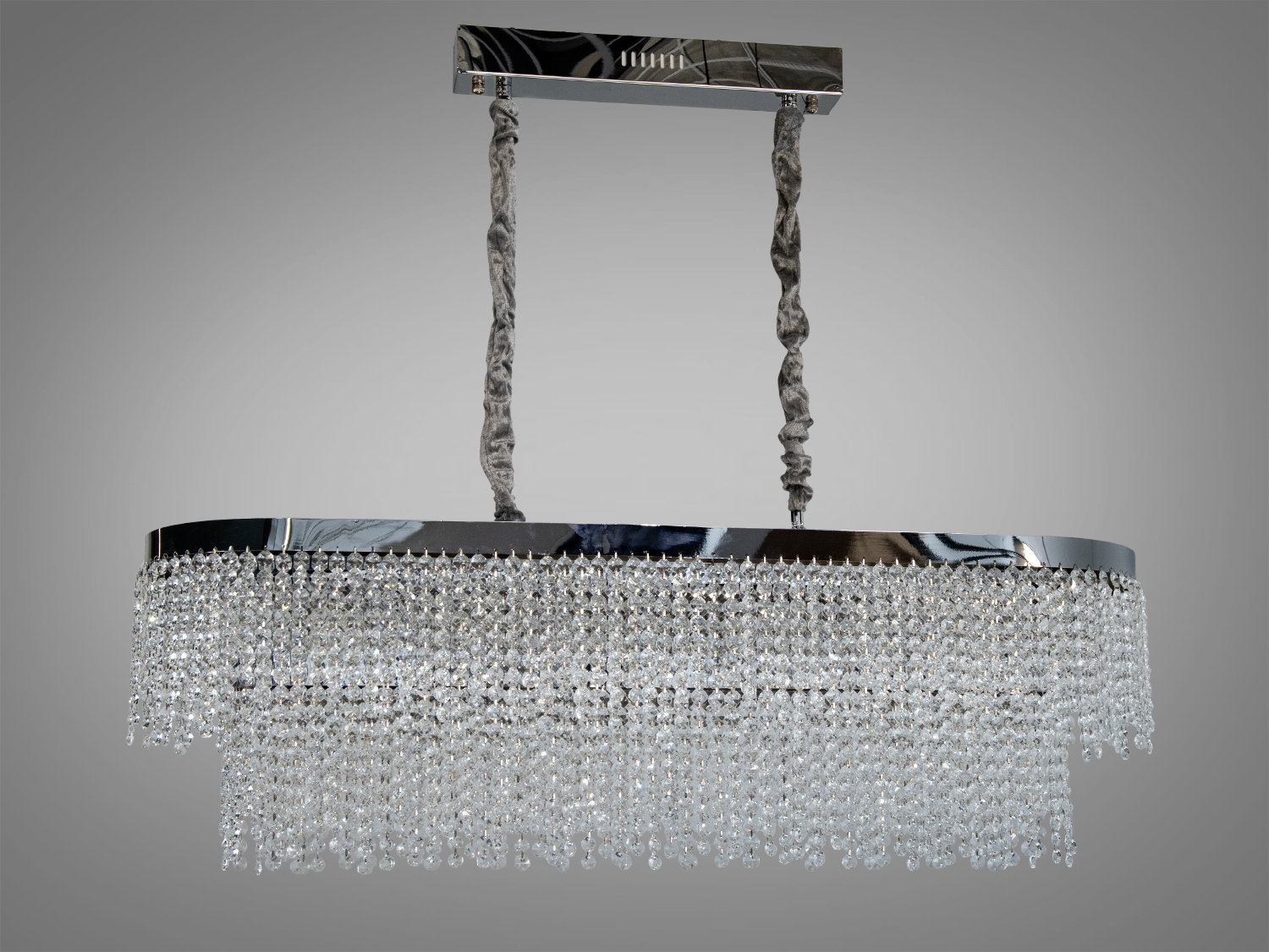 Овальна люстра з блискучими кришталевими підвісками, що підвішена на двох текстильних шнурах. Відмінний вибір для вітальні.