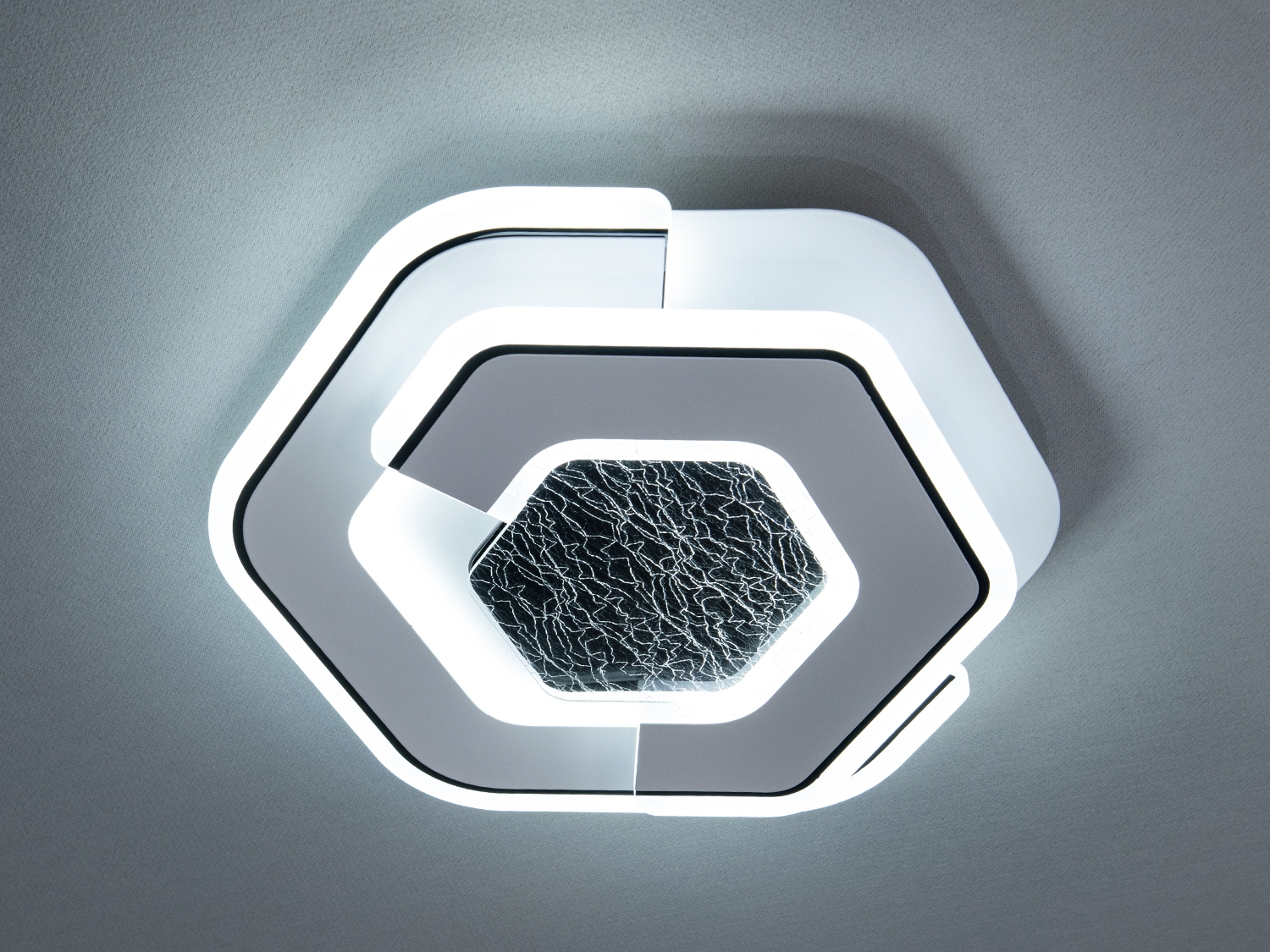 Центральний декоративний елемент акрилового світильника із текстурованою поверхнею нагадує природний малюнок мармуру, що вигідно контрастує з гладкими білими лініями корпусу.