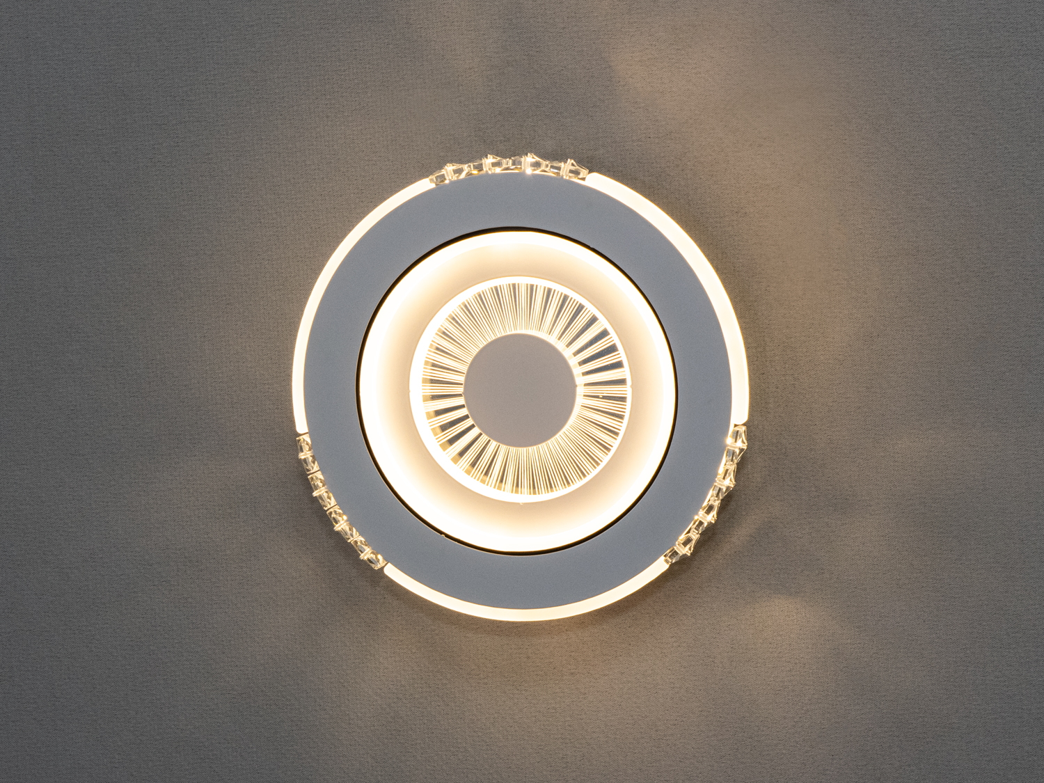 Особливого шарму додають кристалічні вставки по периметру світильника, які мерехтять під час роботи, створюючи ефект дорогоцінних каменів.