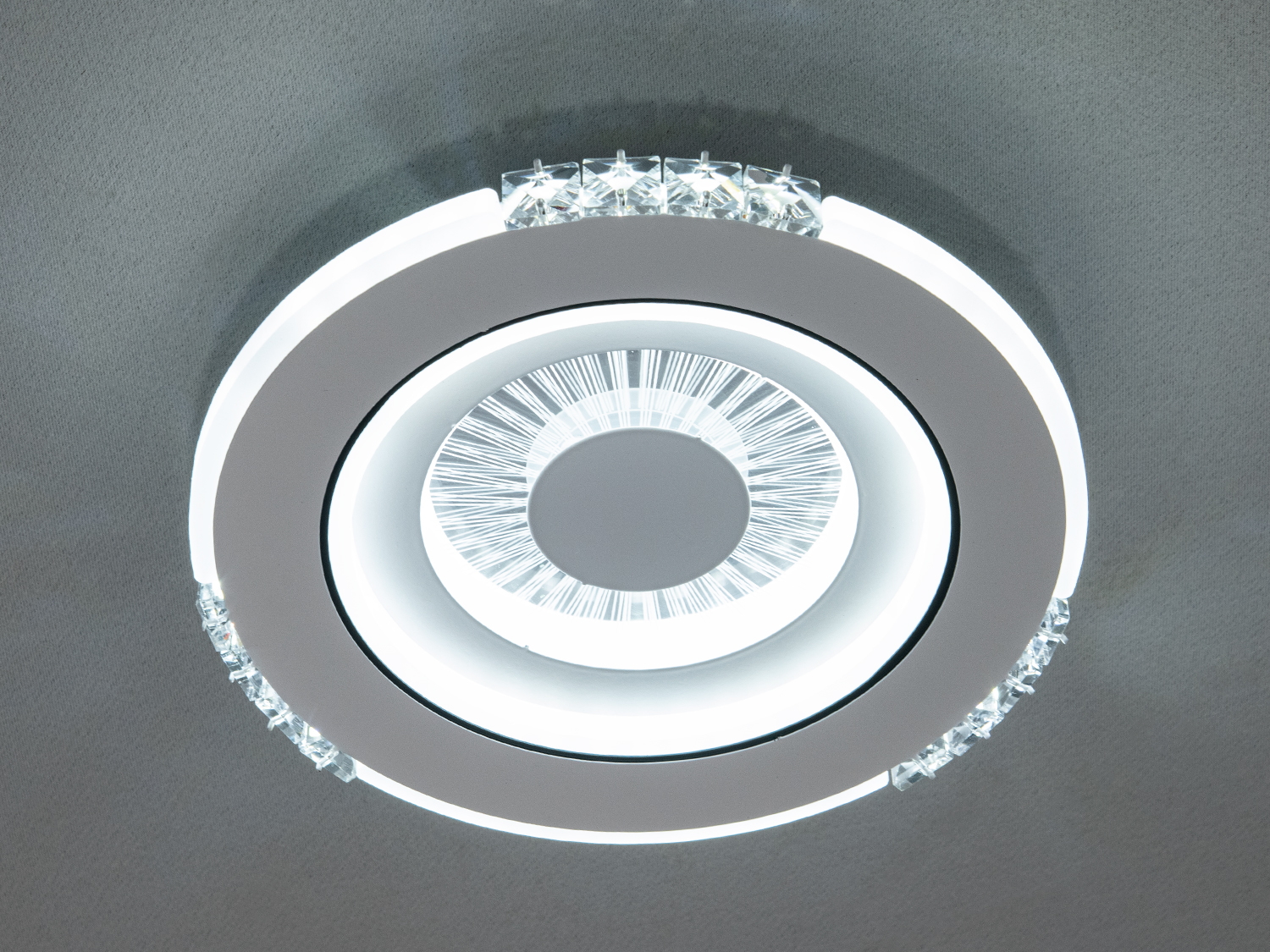 Центральний розсіювач лед світильника, схожий на оптичну лінзу, розділений на тонкі промені, які, мов сонячні, розходяться від центру до країв. 