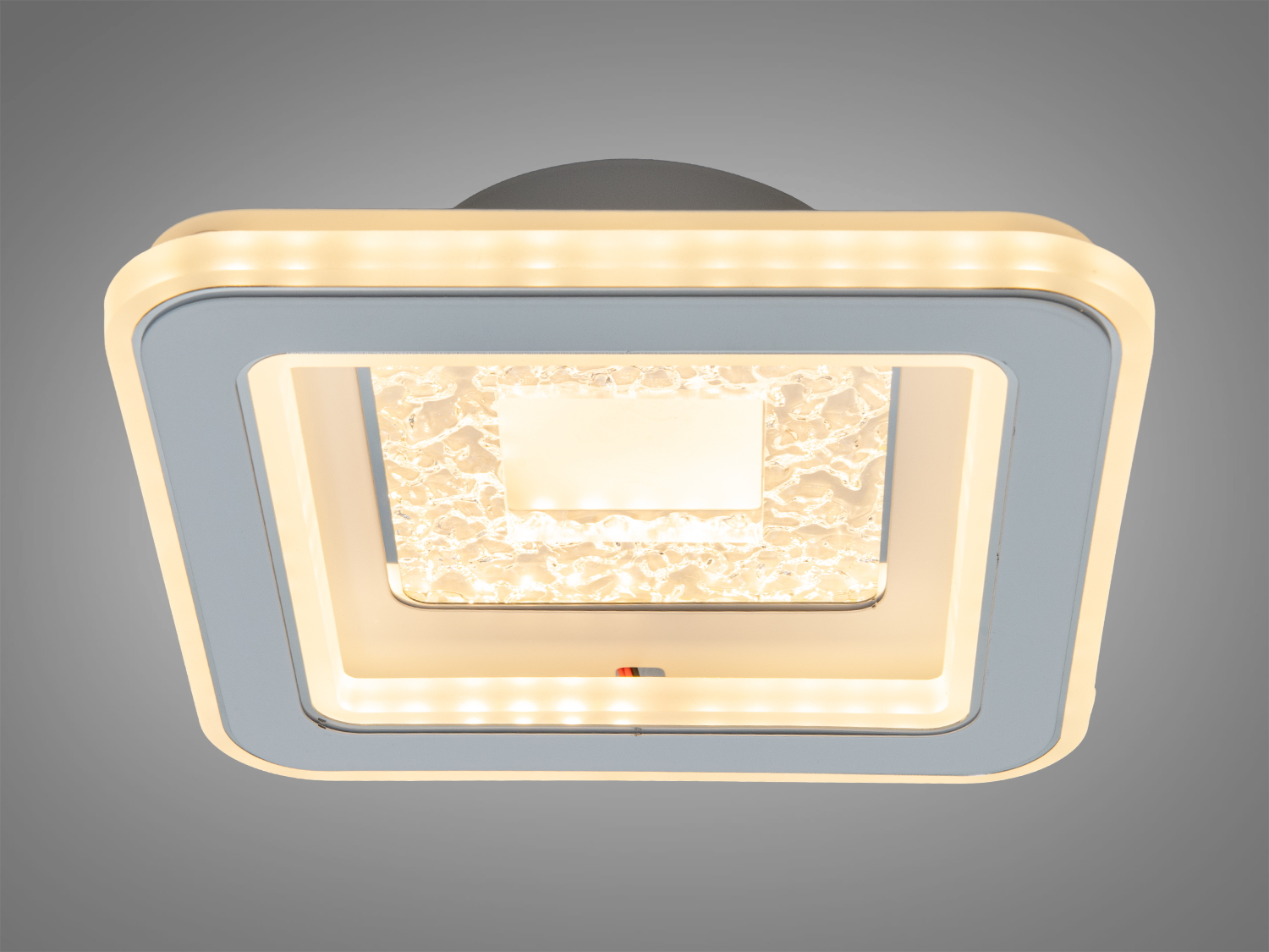 Квадратний світильник з теплим білим світлом і текстурованою центральною частиною. Підходить для спальні.