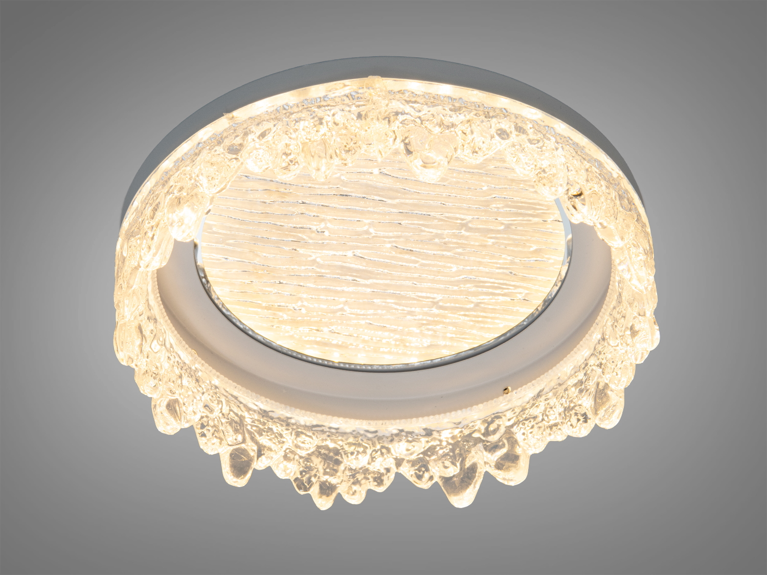 Світильник з теплим світлом, круглої форми, з текстурованою поверхнею. Виготовлений зі скла, підходить для затишних інтер′єрів.