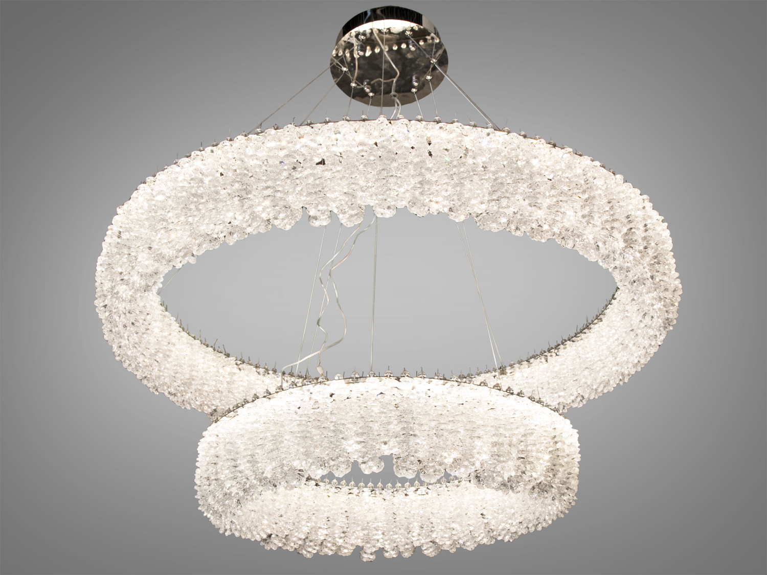 Люстра з двома кільцями, прикрашеними прозорими кристалами. Ідеальна для вітальні. Світлодіодне освітлення забезпечує яскраве світло.