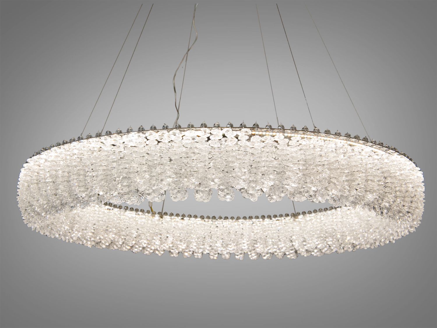 Підвісна люстра з кришталю у формі кільця з рівномірним розподілом світла. Підходить для просторих приміщень.