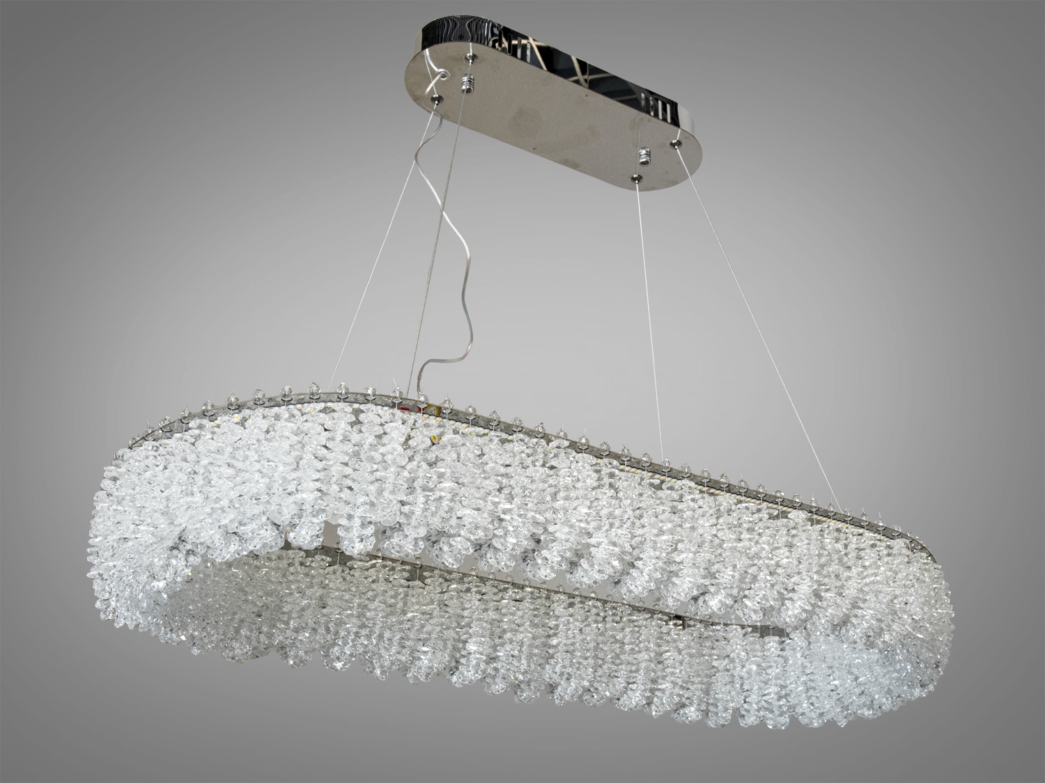 Елегантна люстра з металевою основою, підвішена на тросах, підходить для високих стель.