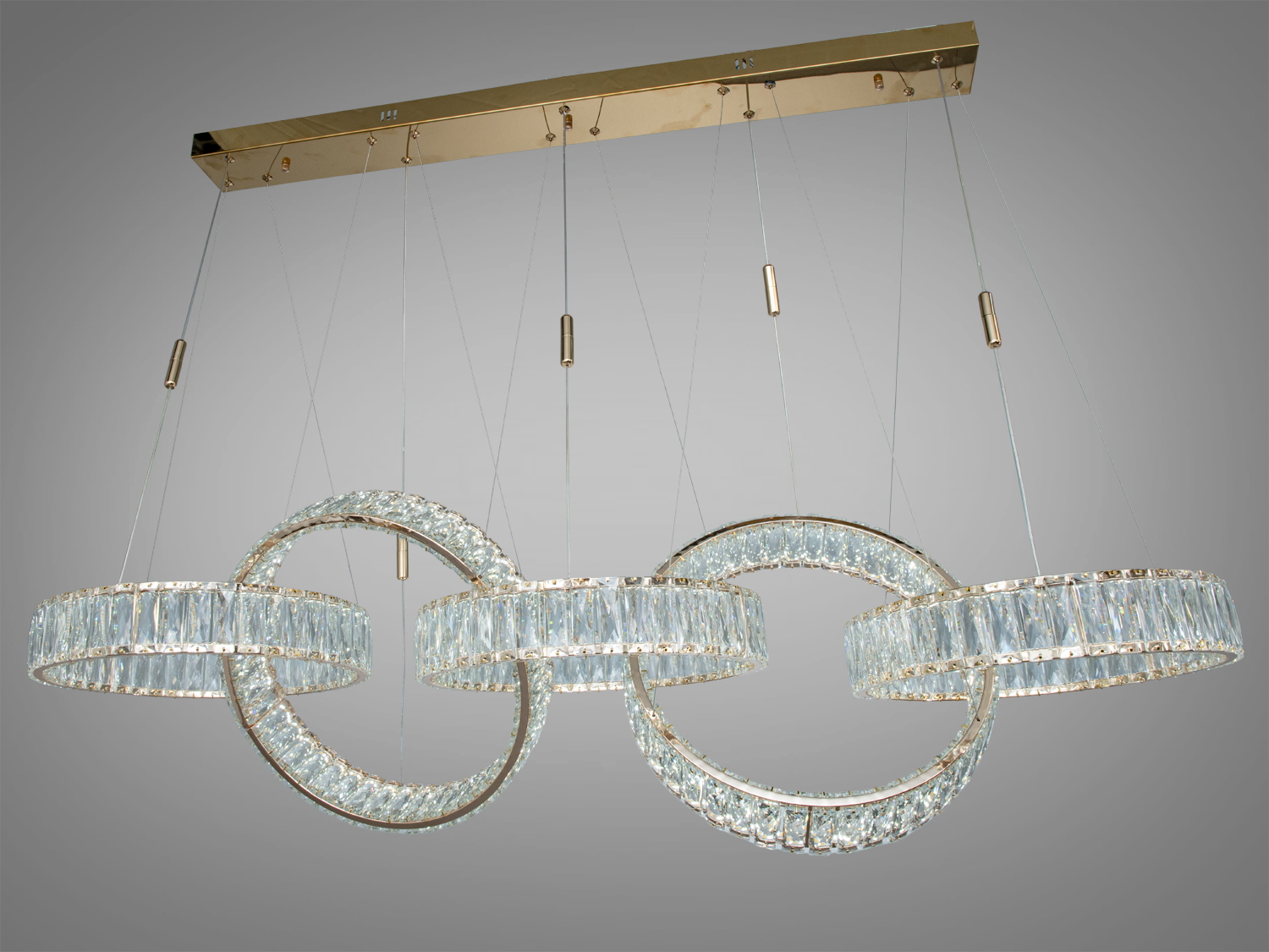 Стильна люстра з пятьма кришталевими кільцями, закріплена на металевій основі. Підходить для високих стель.