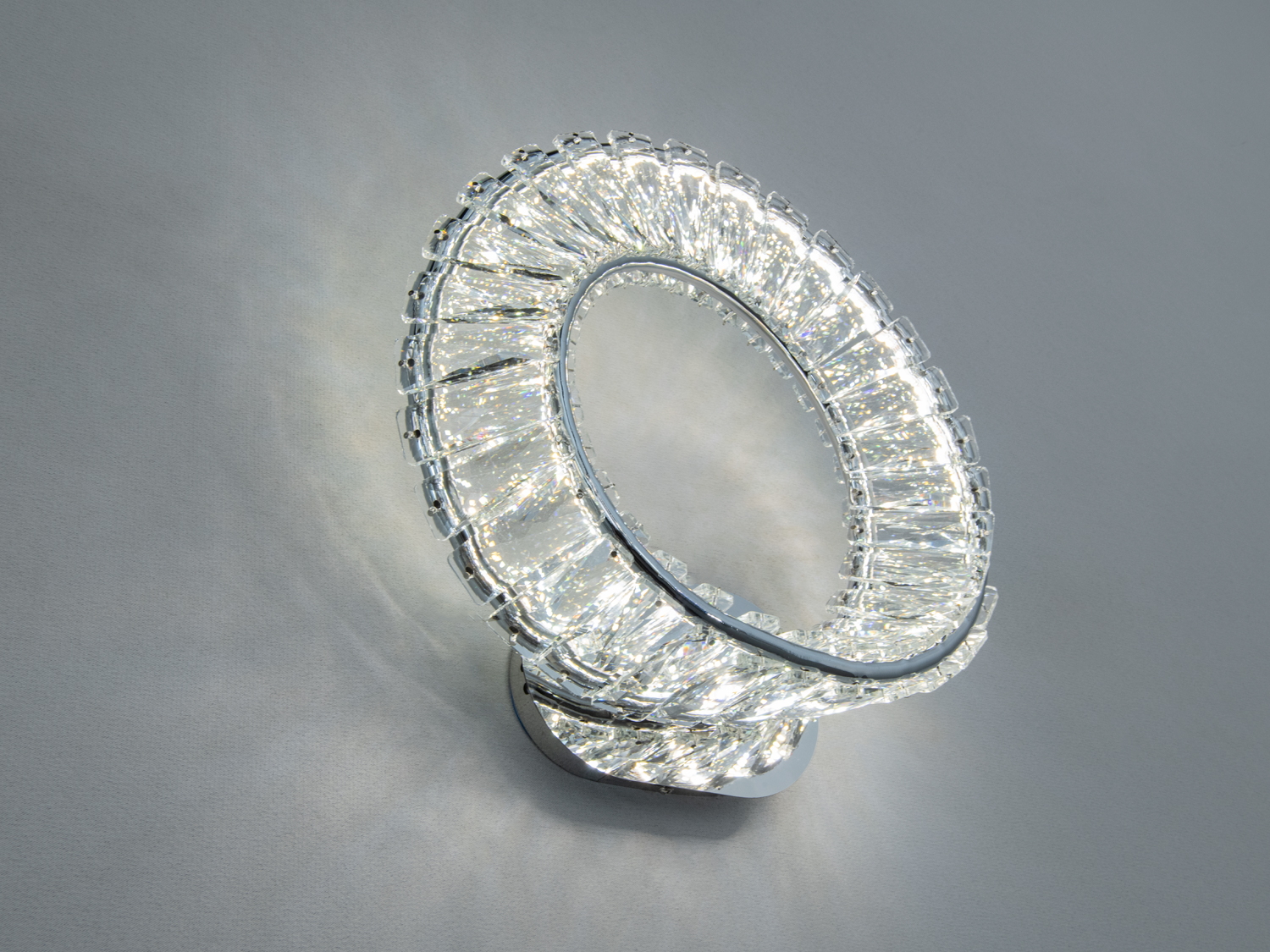 Настінний світильник з кришталевими елементами, що створюють ефект сяйва. Призначений для сучасного інтер′єру.