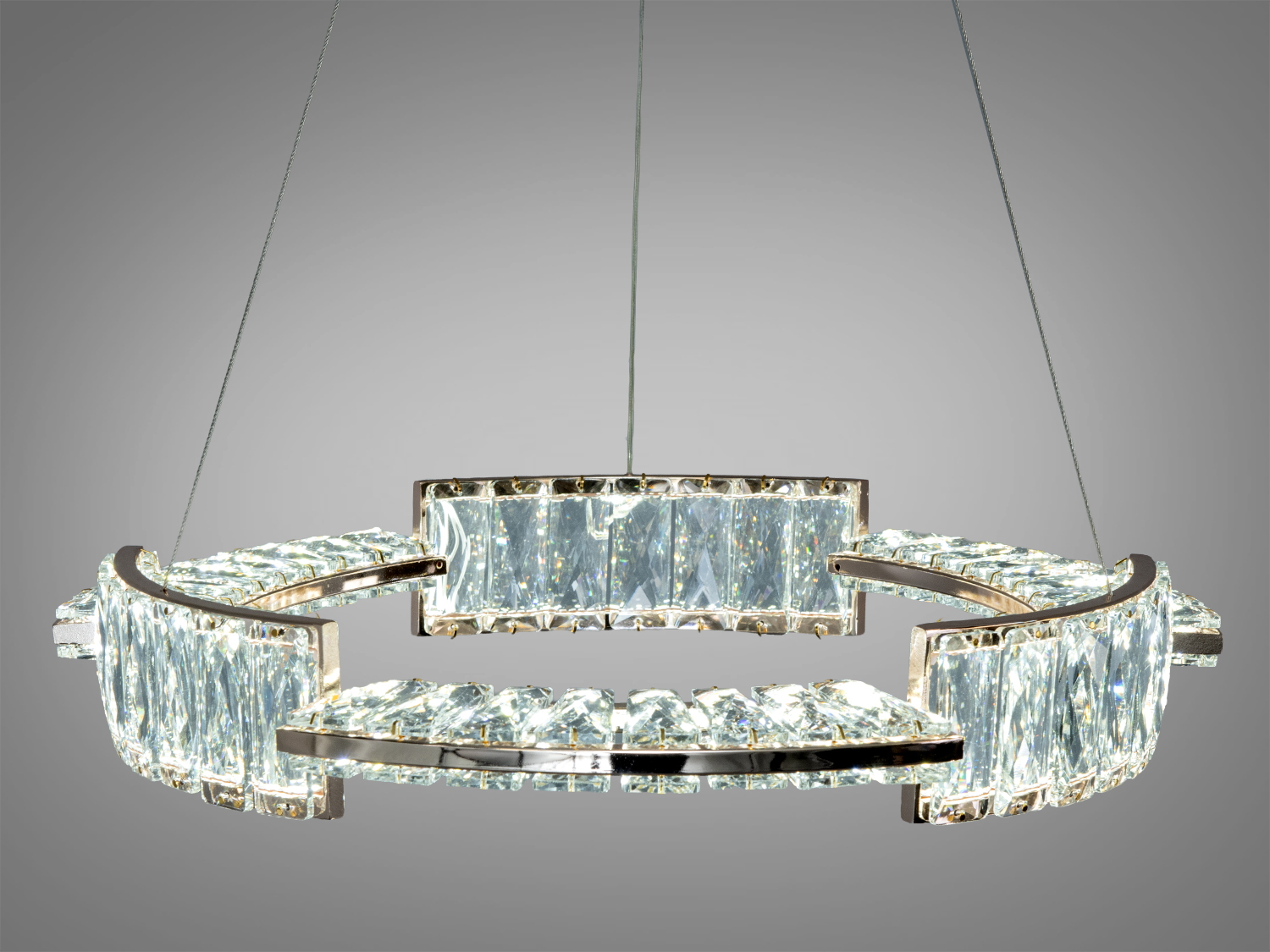 Кругла люстра з кристалами, підвішена на тонких тросах. Ідеально підходить для сучасних інтер′єрів, забезпечуючи яскраве освітлення.