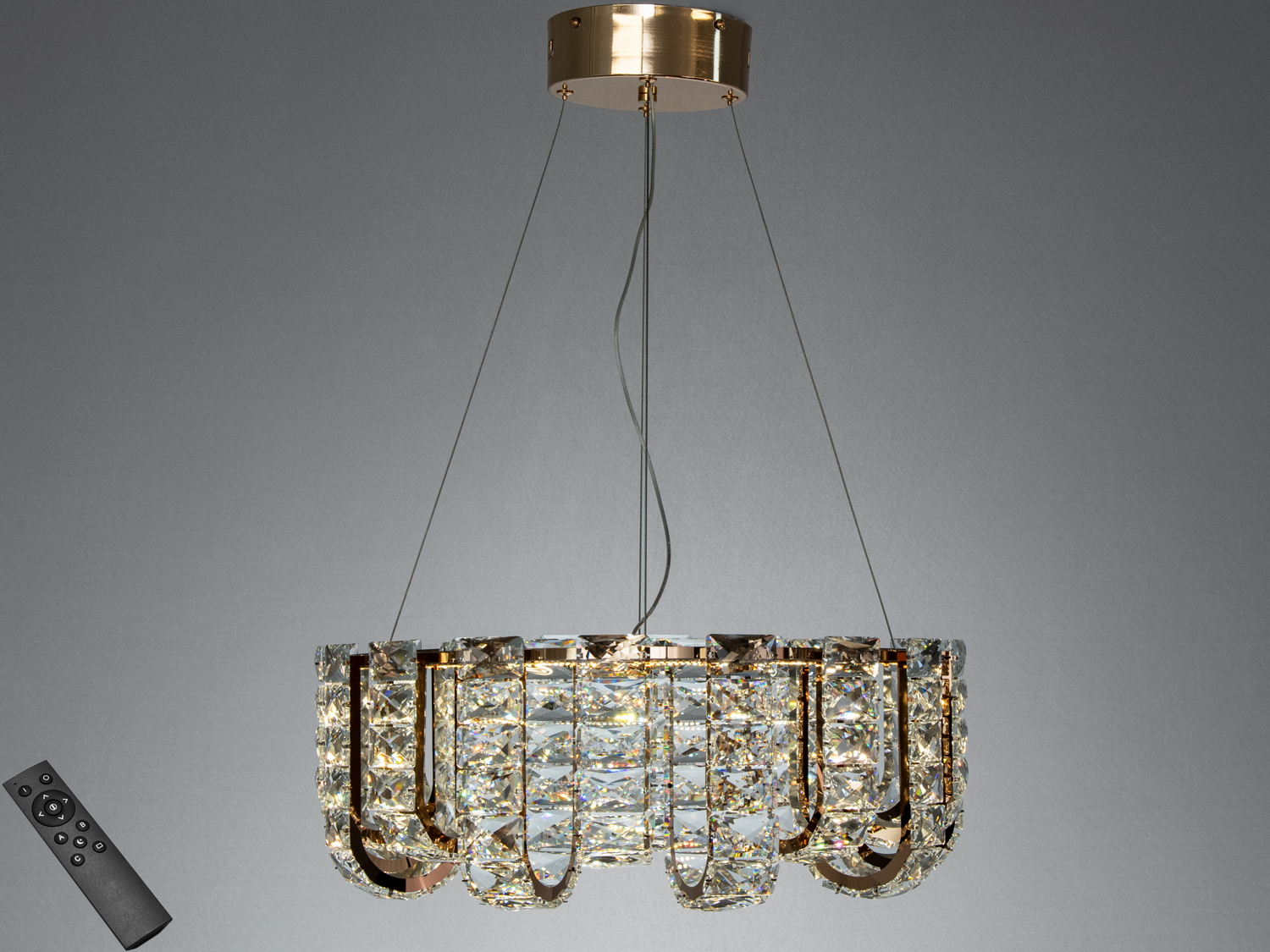 Підвісна люстра з кришталевими елементами у формі арок, оснащена пультом дистанційного керування для зручного регулювання освітлення.