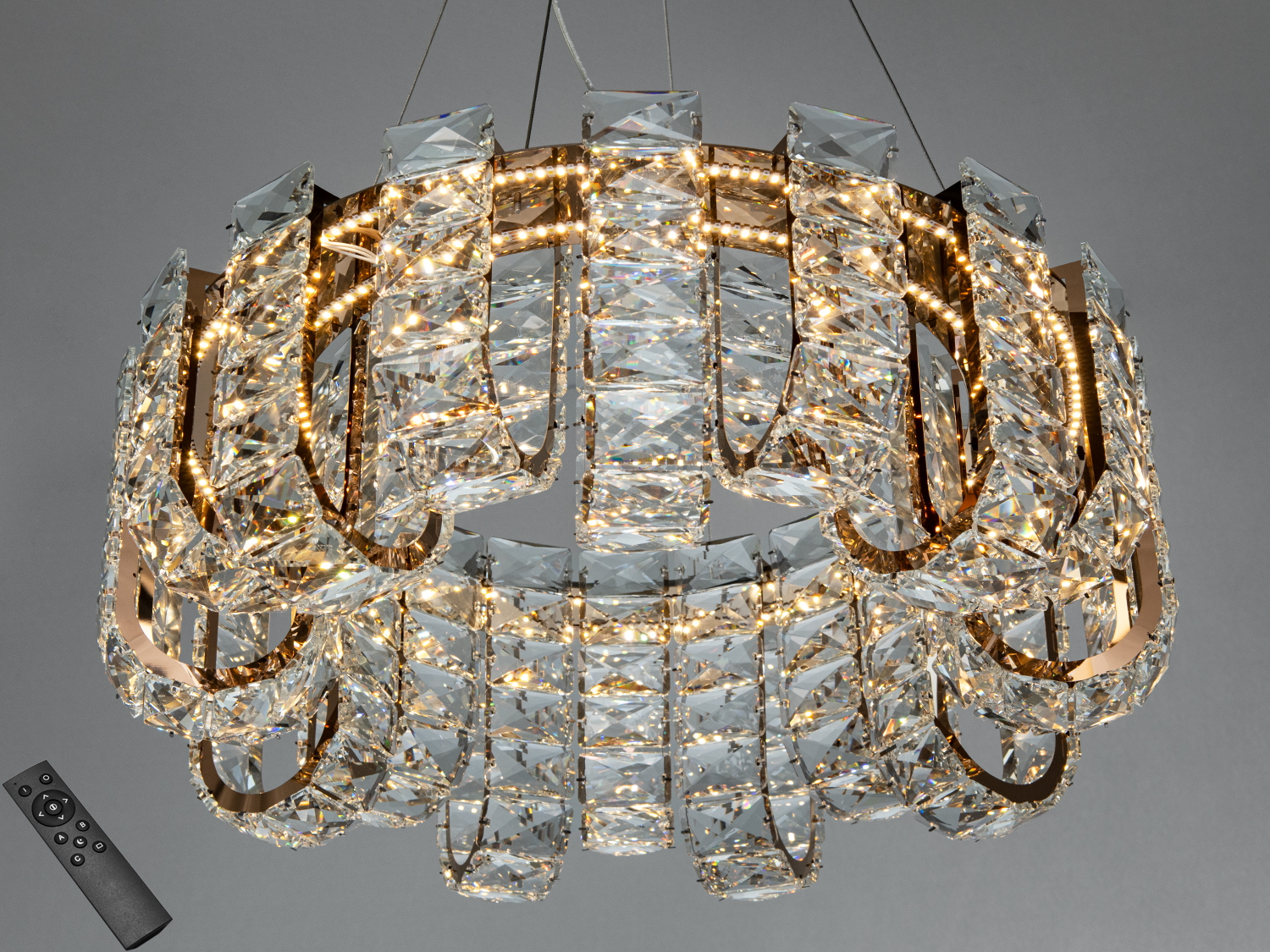 Підвісний світильник зі спіральним дизайном, прикрашений кришталевими елементами, керується дистанційним пультом для регулювання освітлення.