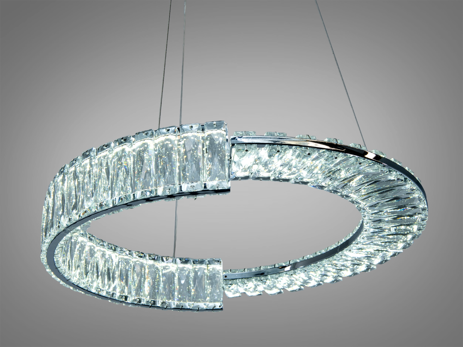 Кришталевий підвісний світильник у формі кільця з прозорими елементами. Підходить для віталень або їдалень.