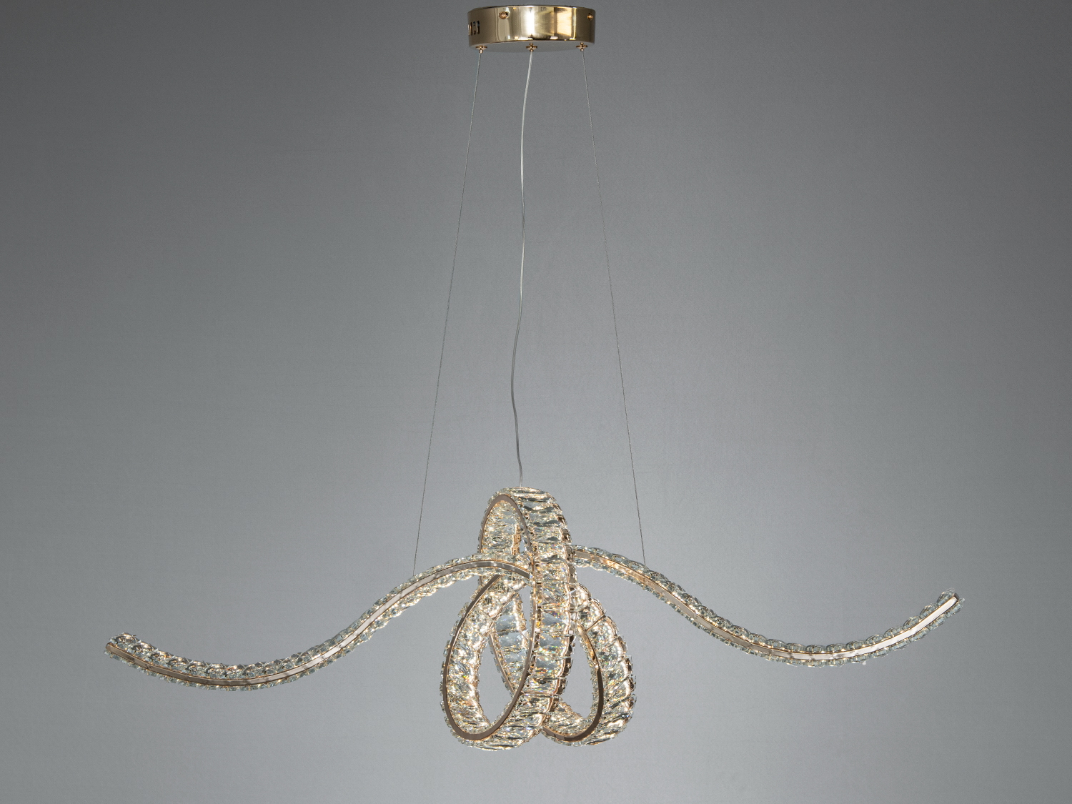 Підвісна люстра з вигнутими променями, що створюють динамічний дизайн. Металевий монтаж додає міцності, підходить для вітальні або їдальні.