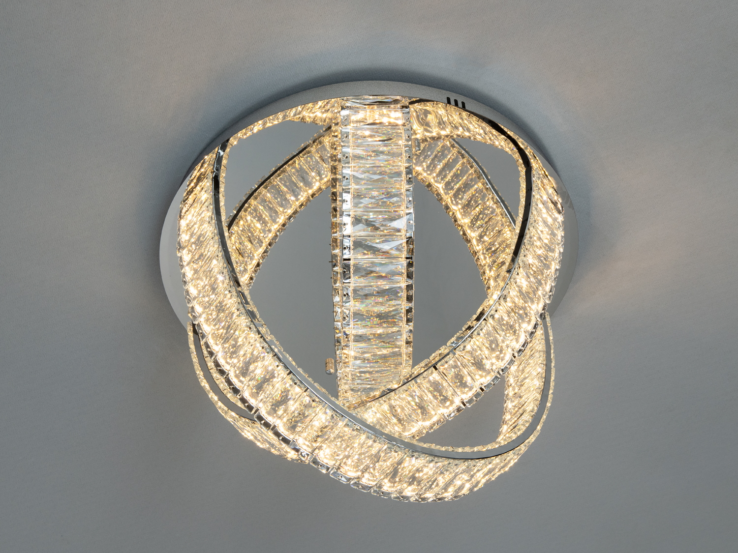 Світильник з трьома переплетеними кристалічними кільцями, матовий корпус, підходить для спальні.