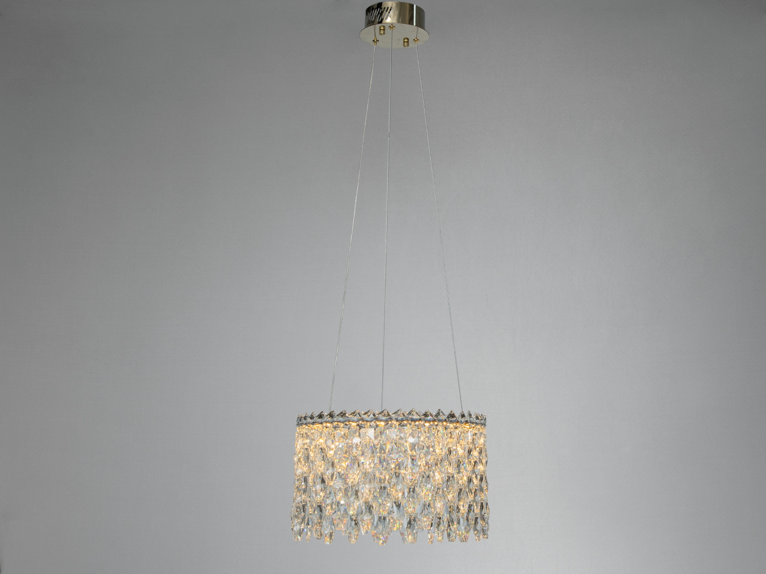 Підвісна люстра з кришталевими елементами, закріплена на стелі. Ідеальна для сучасного інтер′єру.