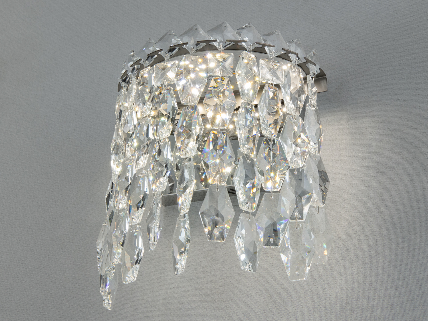Кришталевий настінний світильник з підвісками, що відбивають світло. Ідеальний для вітальні, додає елегантності та блиску приміщенню.