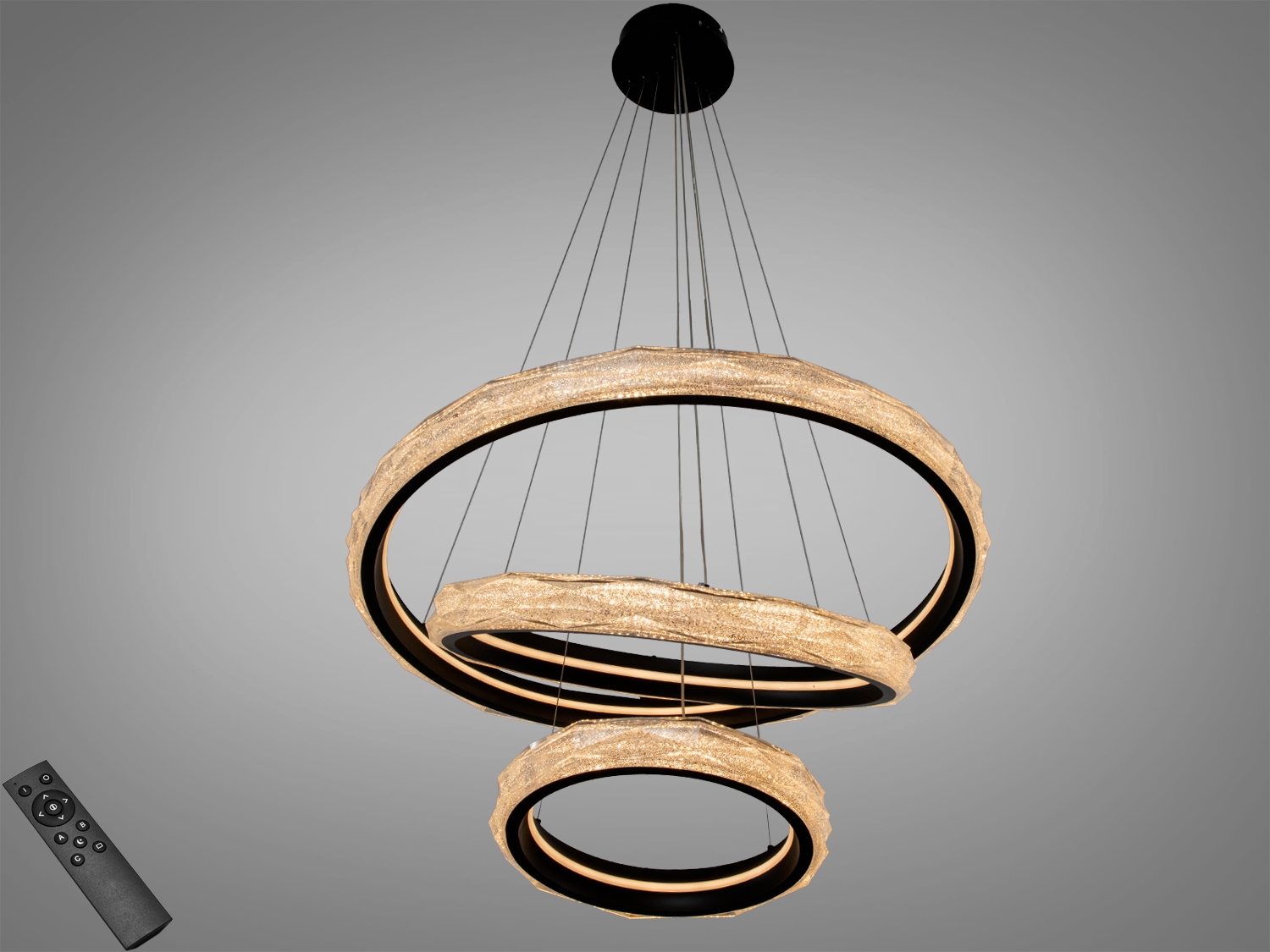 Підвісний світильник з трьома кільцями, що підвішені на тонких дротах. Має дистанційне керування для зручності використання.
