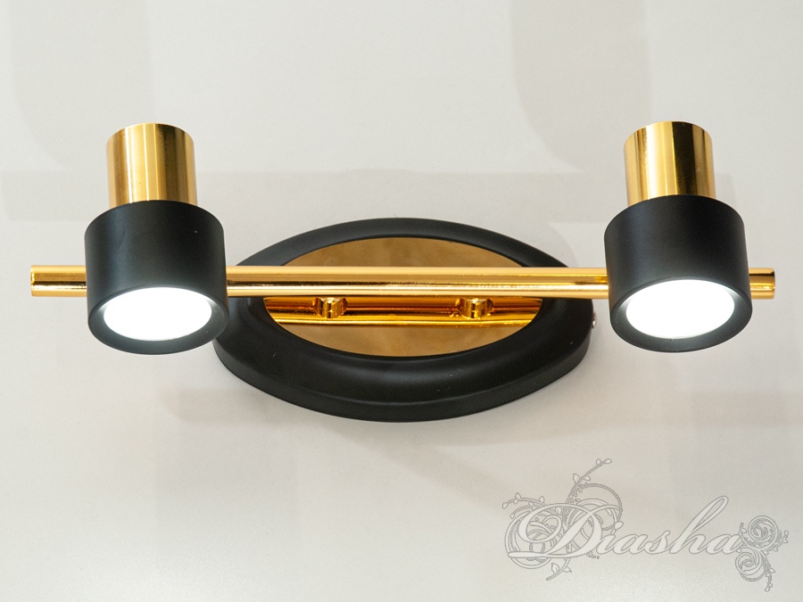 Настінний світильник із двома чорними плафонами та золотистою основою. Підходить для освітлення коридорів.
