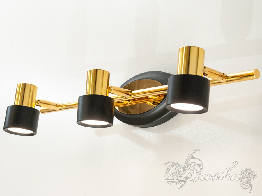 Триламповий світильник із поворотними циліндричними плафонами, виконаний у чорному та золотому кольорах, ідеальний для точкового освітлення.