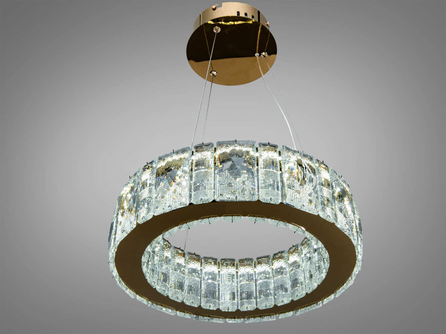 Підвісна люстра з кришталевими деталями, кругла форма, золота основа, створює елегантне освітлення.