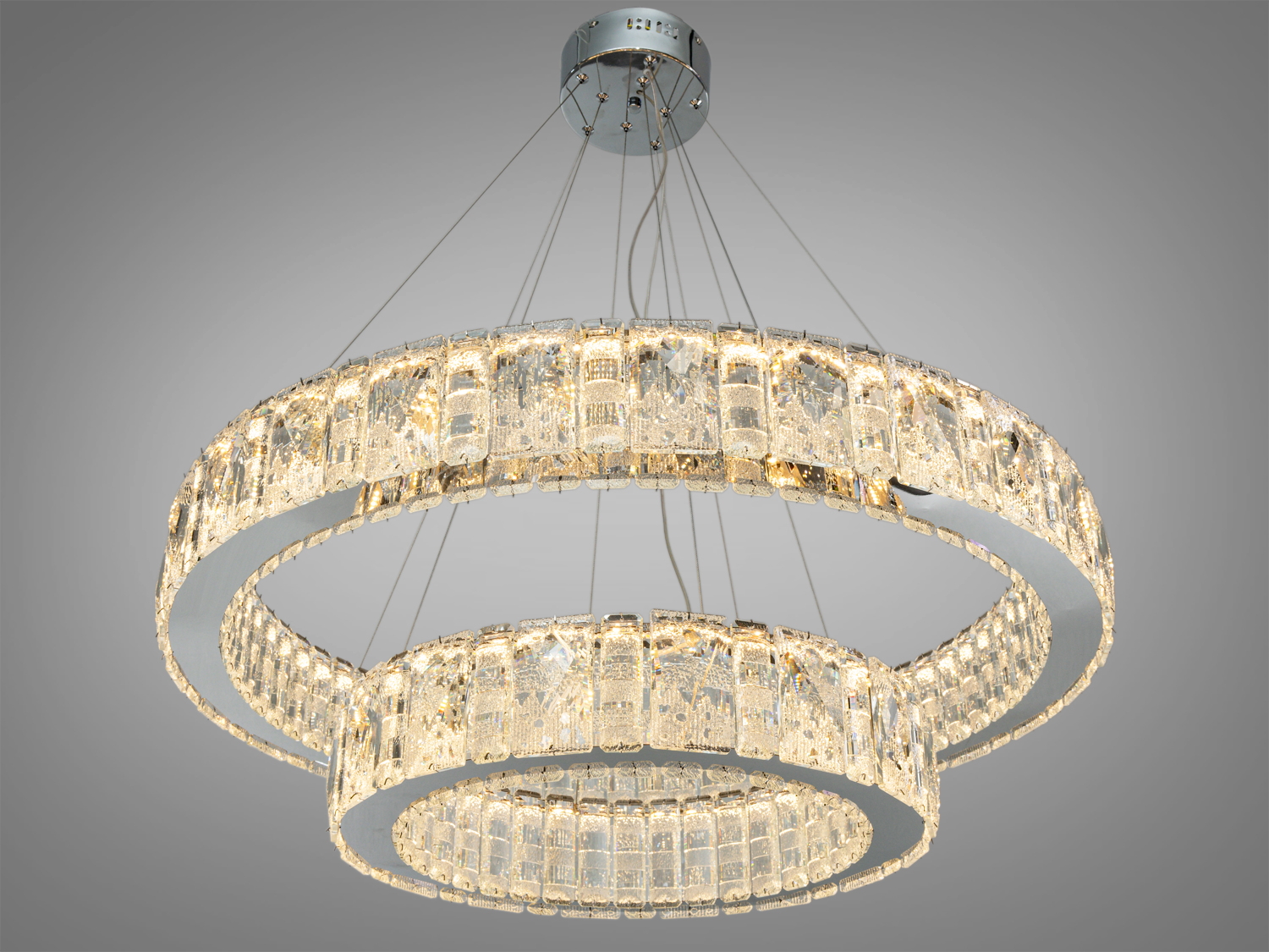 Люстра з теплим світлом, що випромінюється через кришталеві кільця. Підходить для створення затишної атмосфери в будь-якому приміщенні.