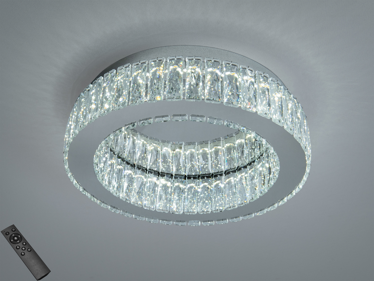 Кругла стельова люстра з кришталевими елементами, що забезпечує яскраве біле світло. Оснащена пультом дистанційного керування для зручності.