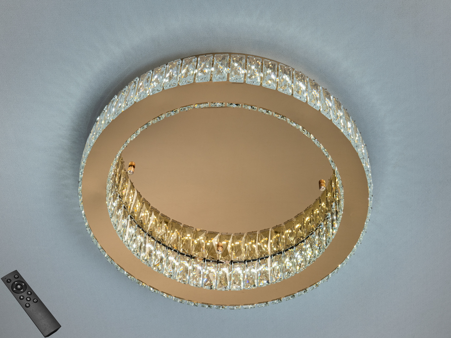 Кругла стельова люстра з кришталевими елементами, оснащена дистанційним керуванням, підходить для сучасного інтер′єру.