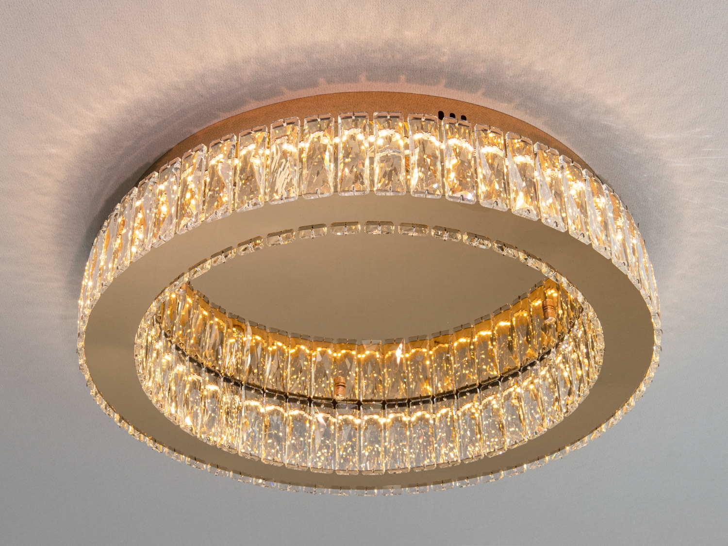 Стельова люстра з кришталевими вставками, створює тепле освітлення, підходить для вітальні або спальні.