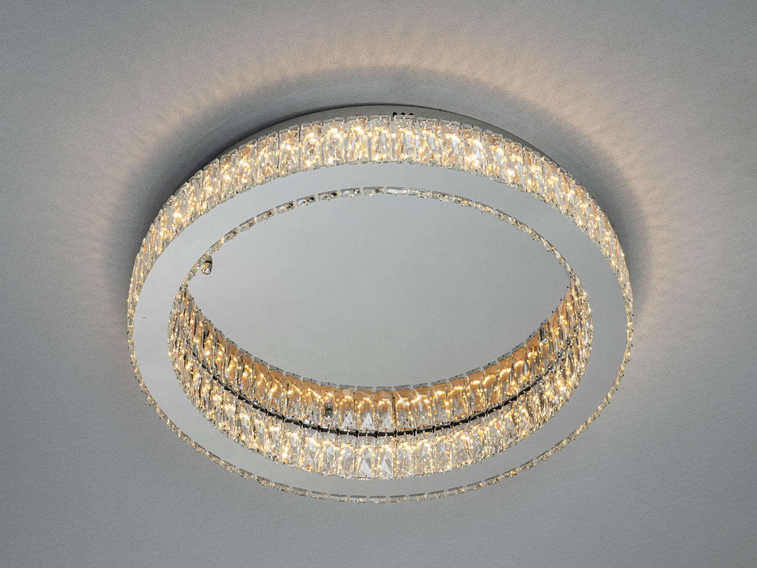 Стельова люстра з двома кільцями кристалів, що створюють м′яке освітлення, підходить для сучасних інтер′єрів.