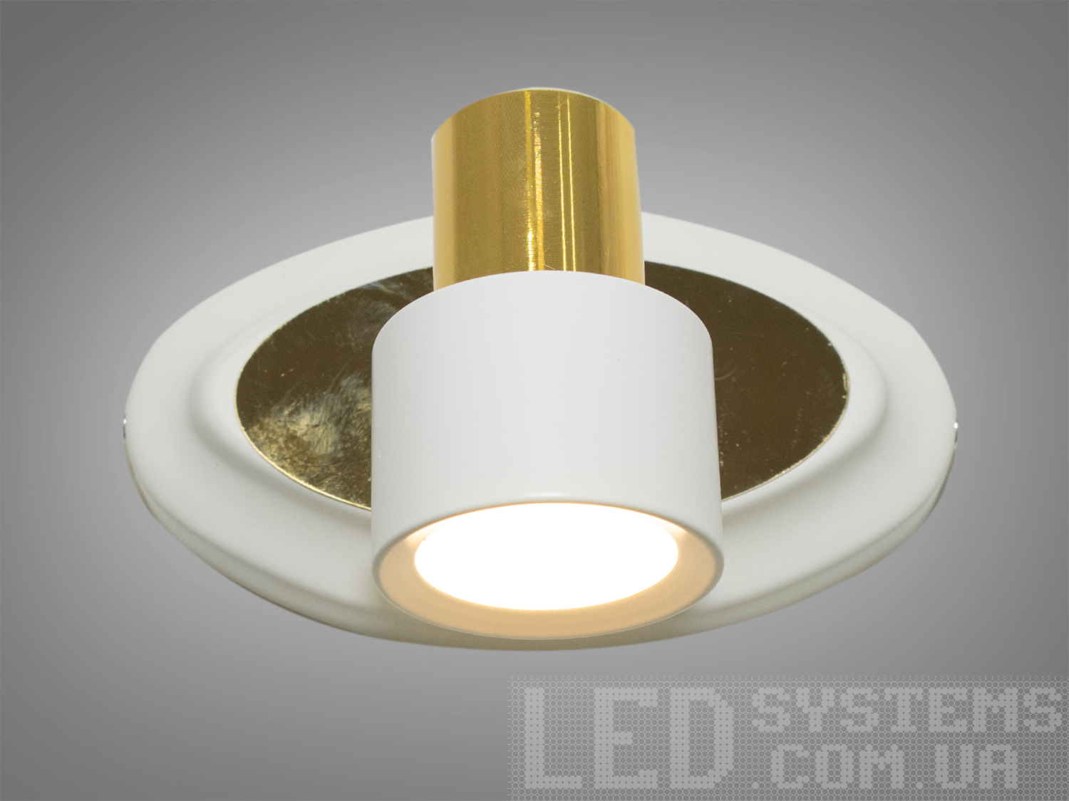 Компактний світильник із білим корпусом, круглою основою та золотистим акцентом. Відмінно підходить для точкового освітлення.