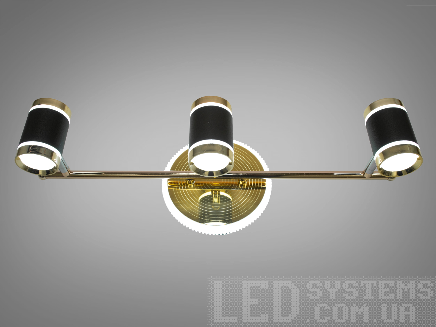 Настінний LED світильник 18 Вт у золотисто‑чорному виконанні з 3 акриловими розсіювачами. Перемикання 3200/4100/6000K зі стінного вимикача для дзеркал і картин.