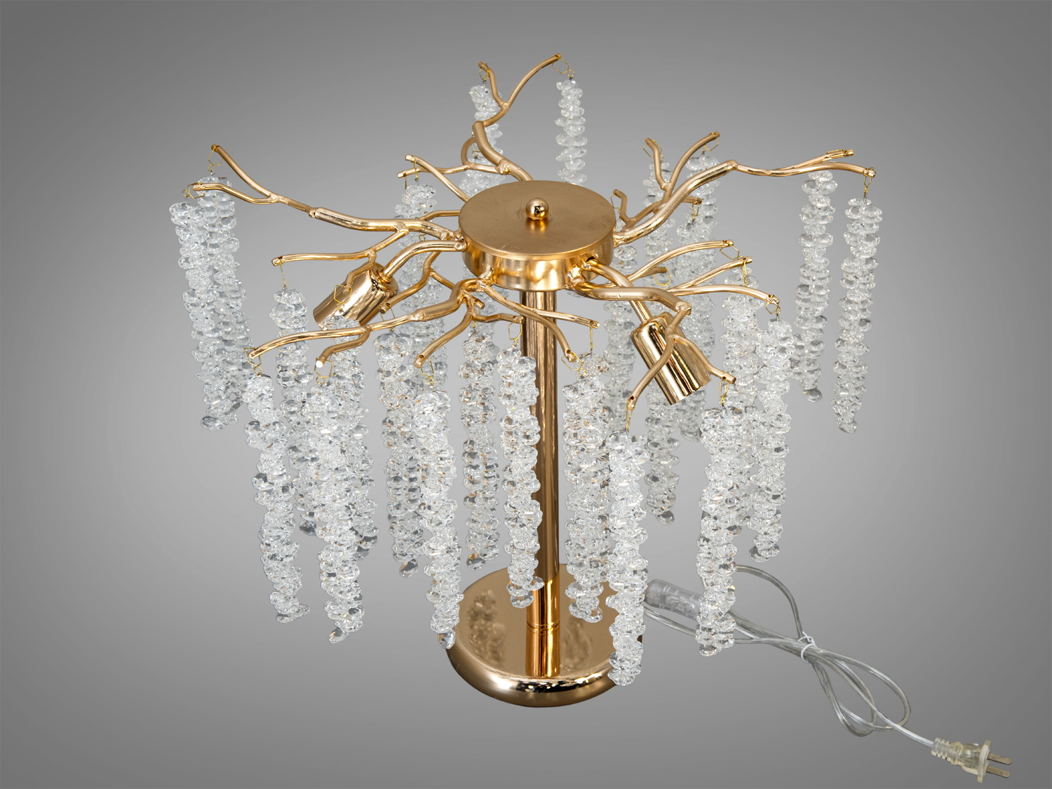 Вид зверху на настільну лампу з кришталевими підвісками на золотистій основі. Лампа має форму дерева з гілками, що додає елегантності інтер′єру.