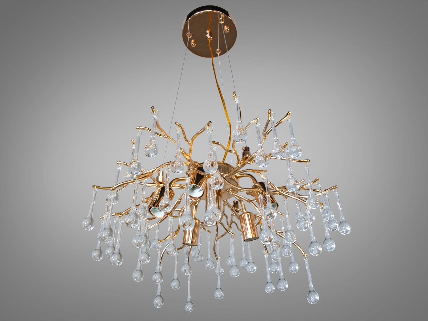 Люстра з золотистими гілками та скляними краплями, що нагадують росу, ідеально підходить для вітальні або їдальні.