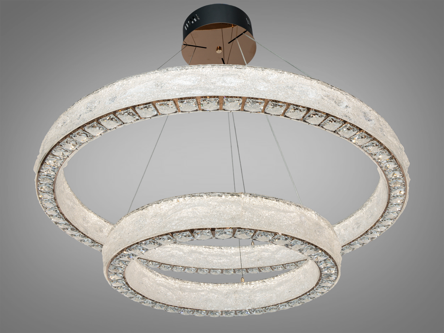 Підвісна люстра з акриловим розсіювачем по центру і внизу кришталевими вставками на кільцях, створює ефектний акцент у просторі, підходить для великих кімнат.