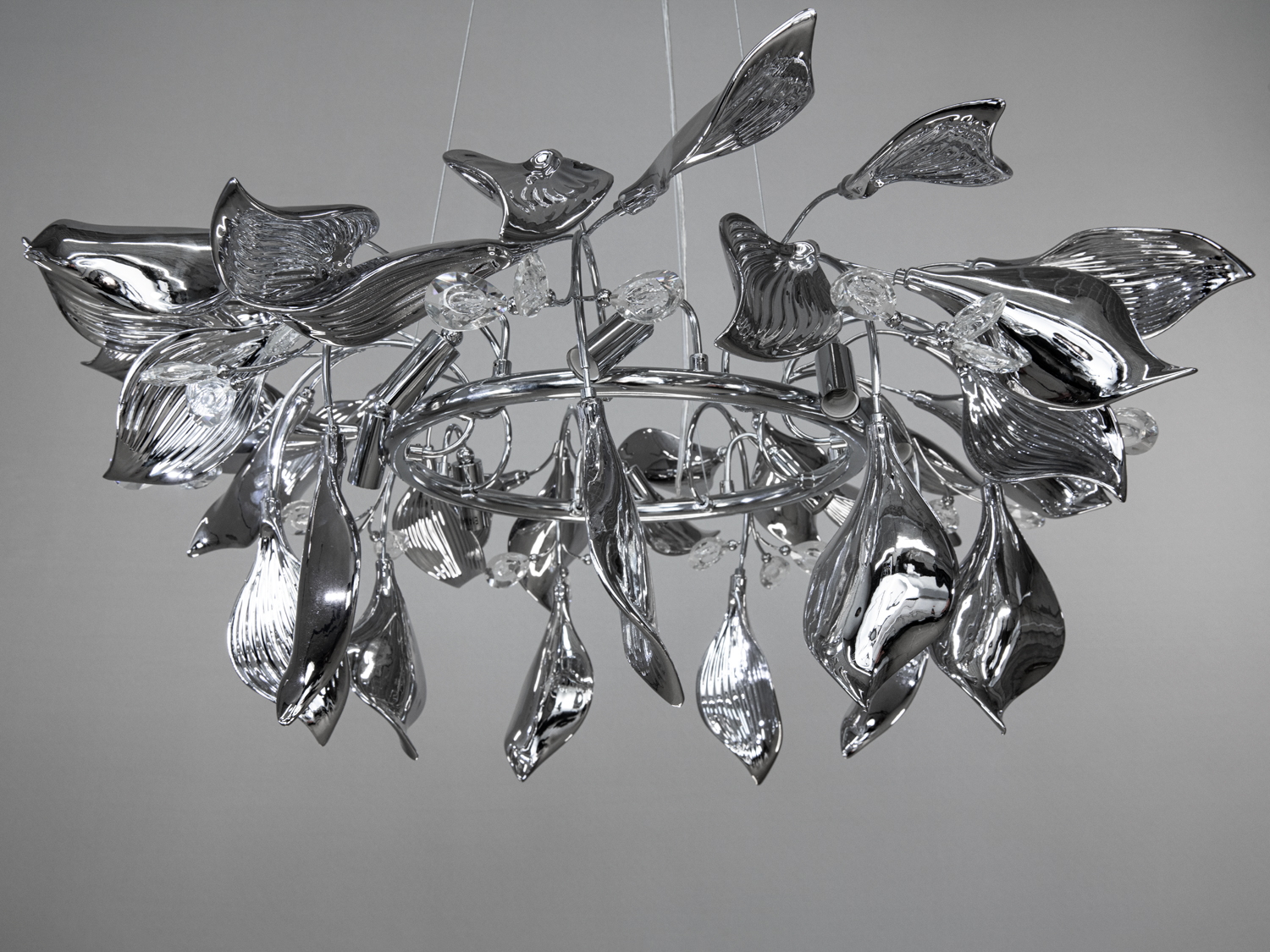 Металева люстра з листям, що має кільцеву основу, ідеально підходить для освітлення вітальні.