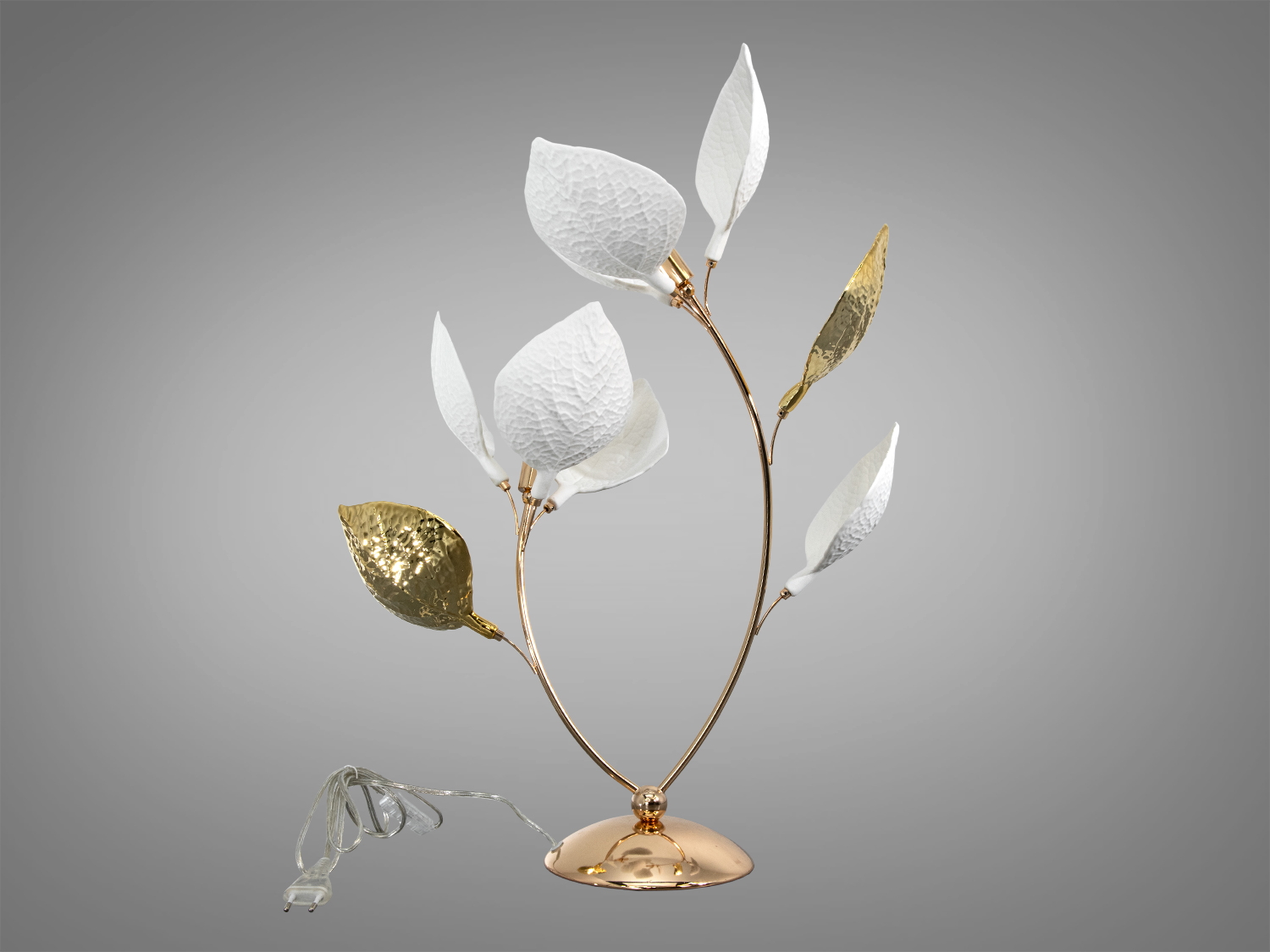 Лампа з білими та золотими листками, оснащена прозорим шнуром живлення. Підходить для настільного використання в сучасному інтер′єрі.