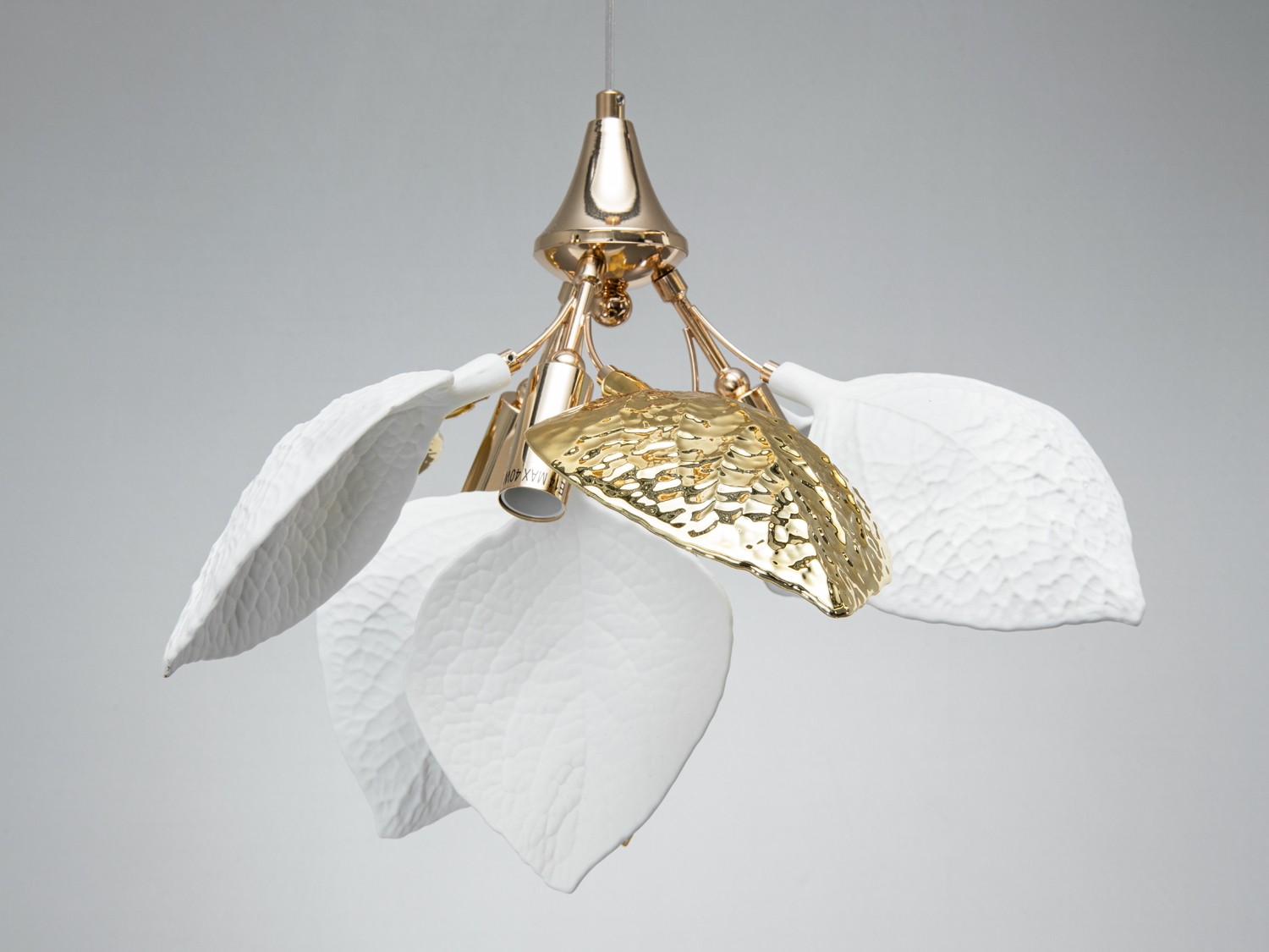 Підвісний світильник з білими та золотими пелюстками, що нагадують квітку. Виготовлений з металу, підходить для сучасного інтер′єру.