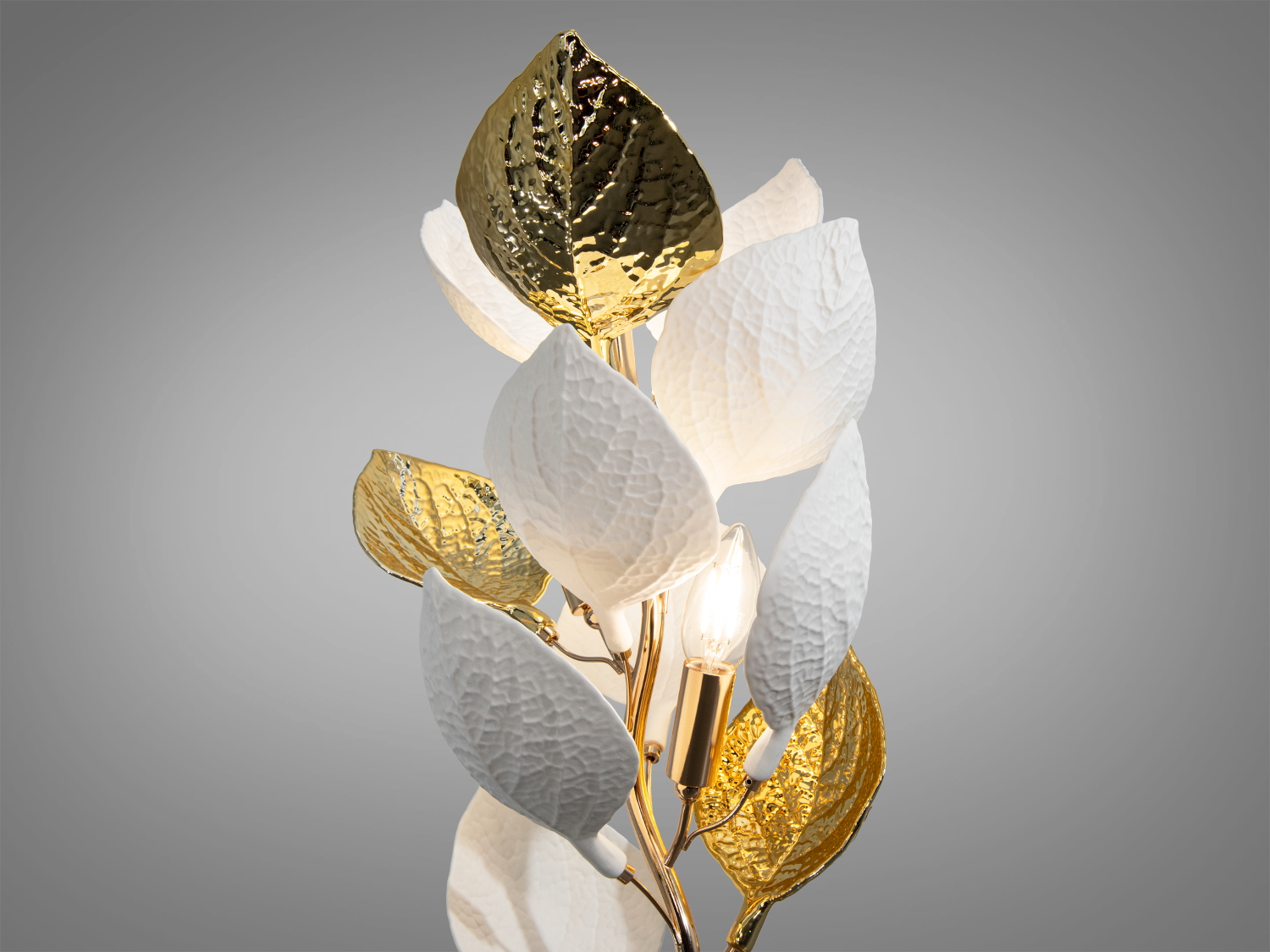 Детальний вигляд лампи з акцентом на золоті та білі листки. Металевий каркас додає елегантності, підходить для декору.