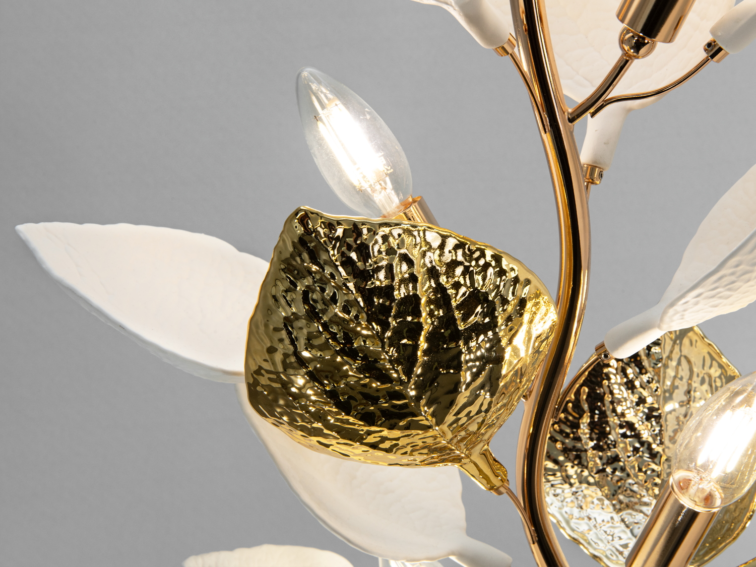 Крупний план золотого листка торшера з лампочкою, що підкреслює витонченість дизайну. Ідеально для стильного декору.