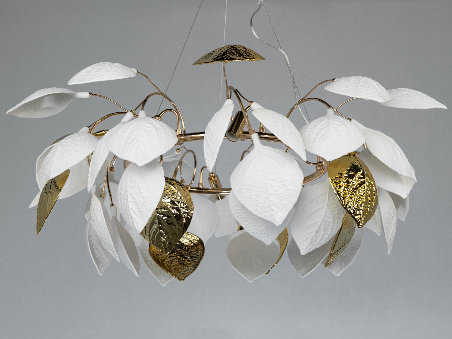 Люстра з підвісними білими та золотими листками, що створюють ефект легкості. Металевий каркас, ідеально для сучасного інтер′єру.