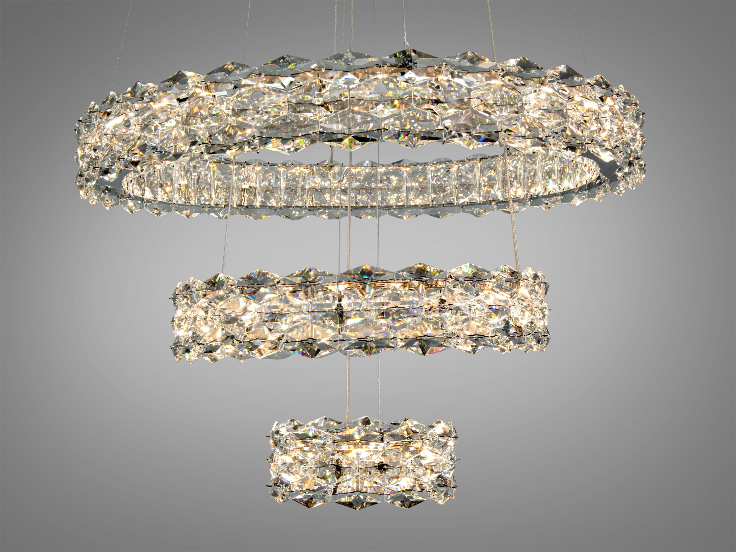 Світильник з кришталевими кільцями, що створюють ефект мерехтіння, підвішений на тонких тросах для елегантного вигляду.